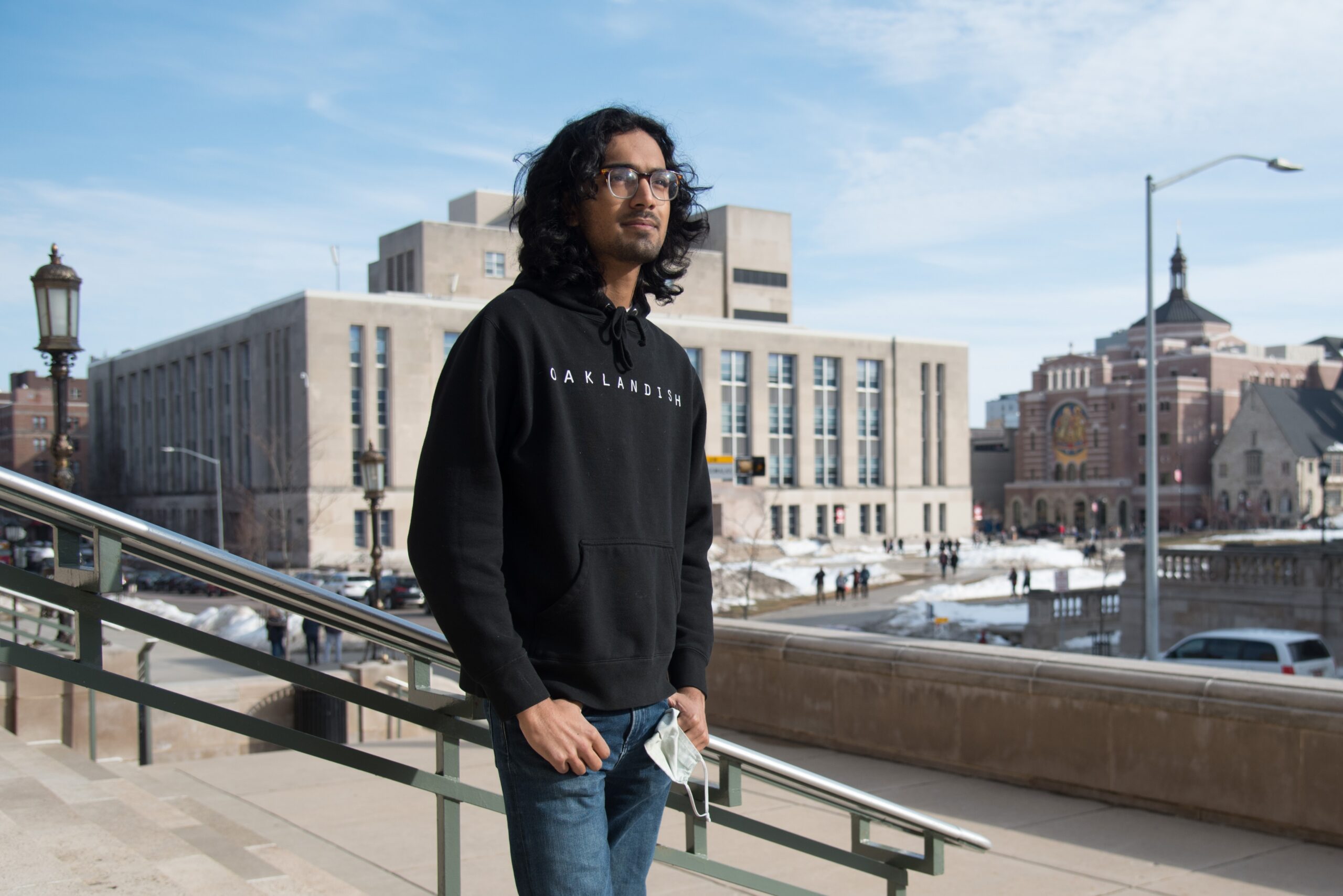 a young man stands outside on campus