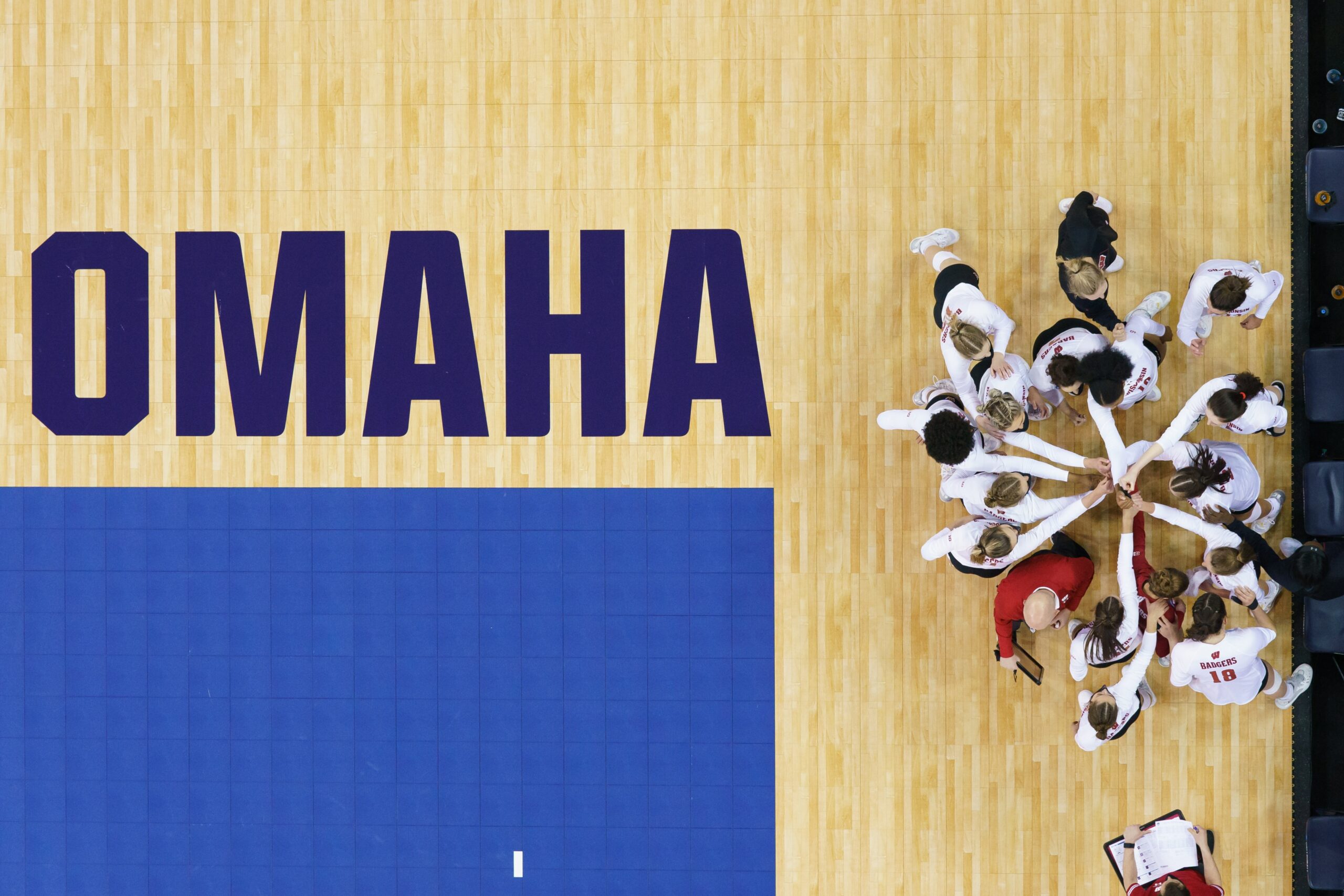 Wisconsin Badgers players put their hands in for a huddle