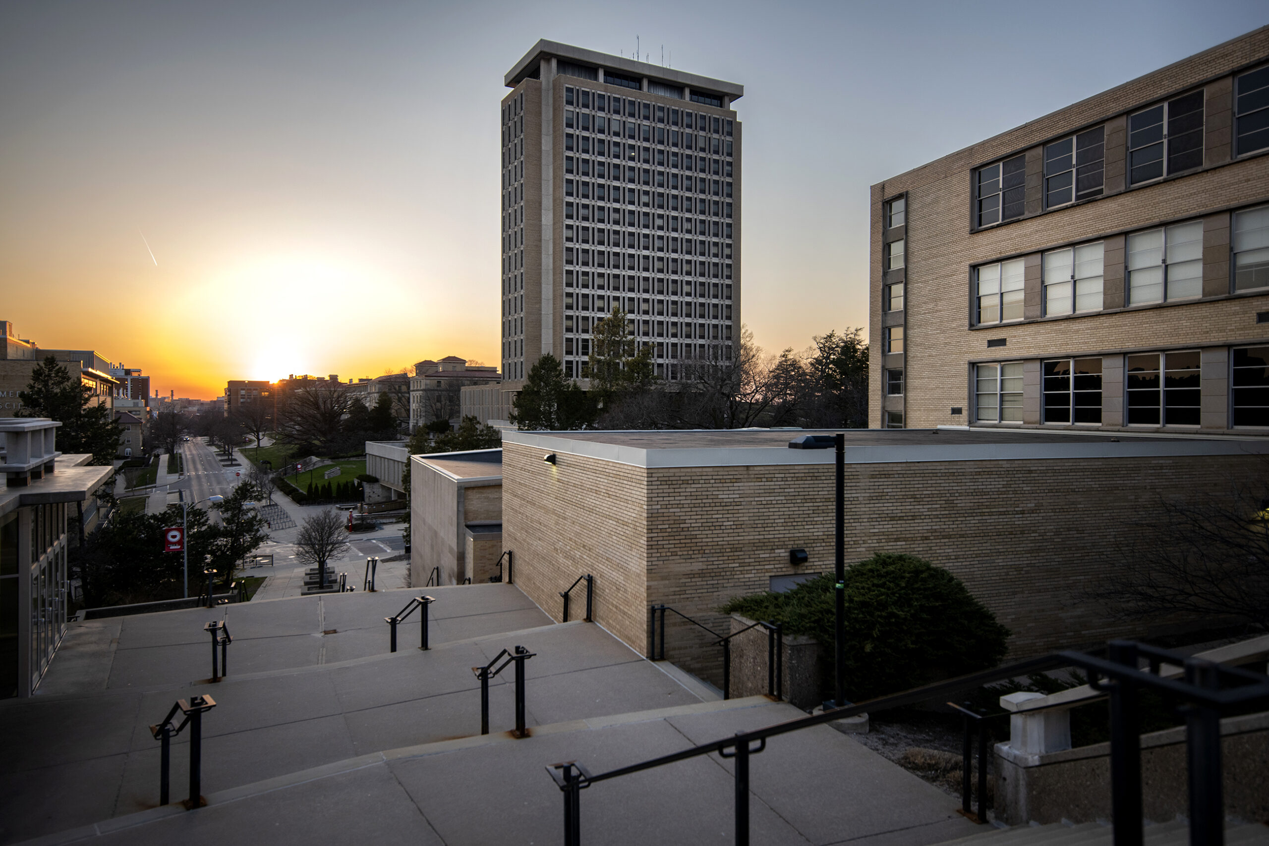 A sunset can be seen behind Van Hise Hall on UW-Madison's campus