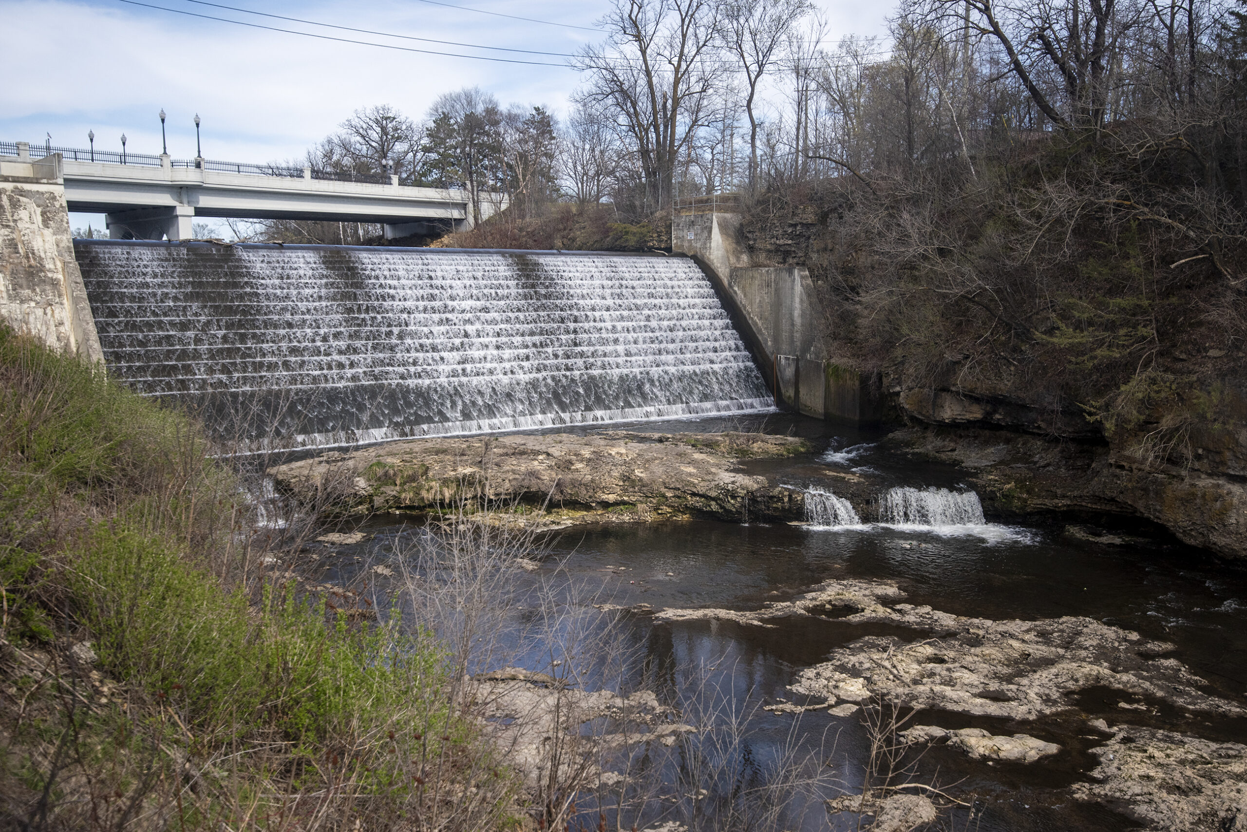 River water flows from under a bridge and down a slope