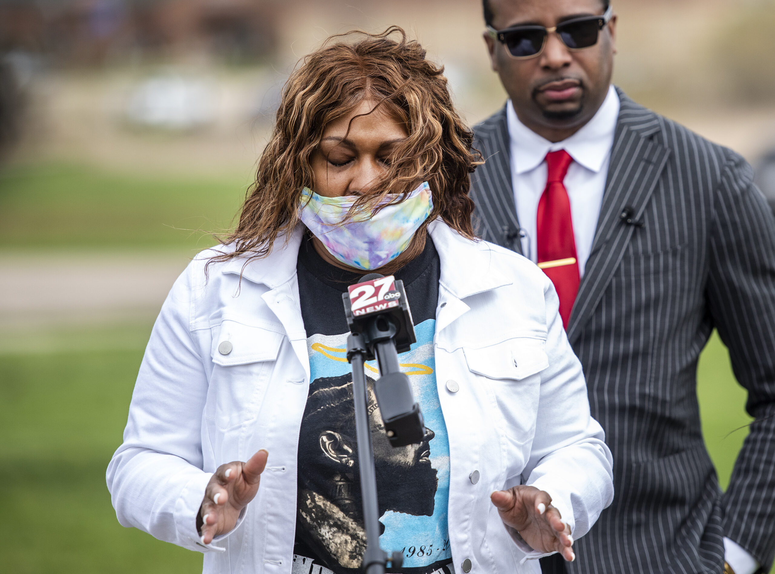 A woman closes her eyes as she speaks about racism.