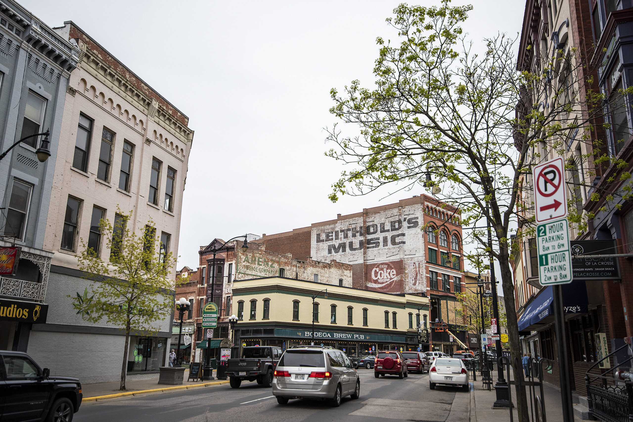 Cars drive by businesses in downtown La Crosse.