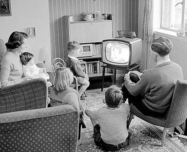 a 1950s family gathers around the TV