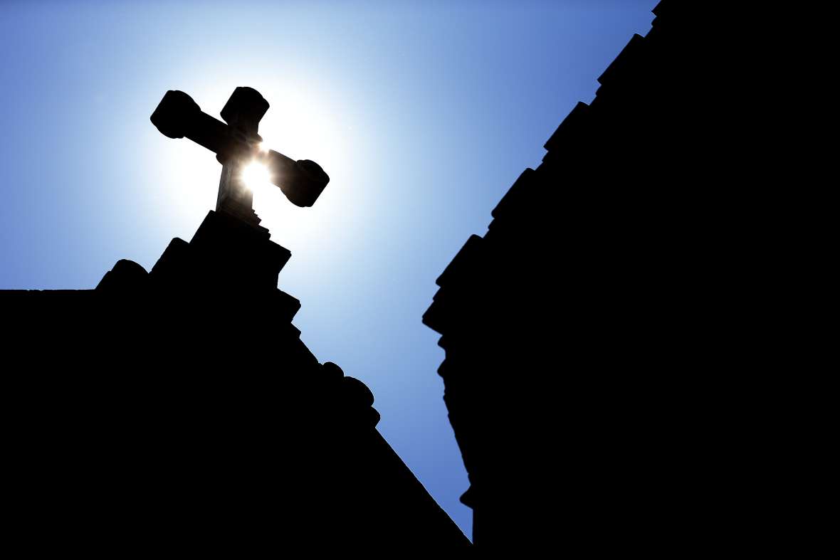 The silhouette of a cross on a Catholic church