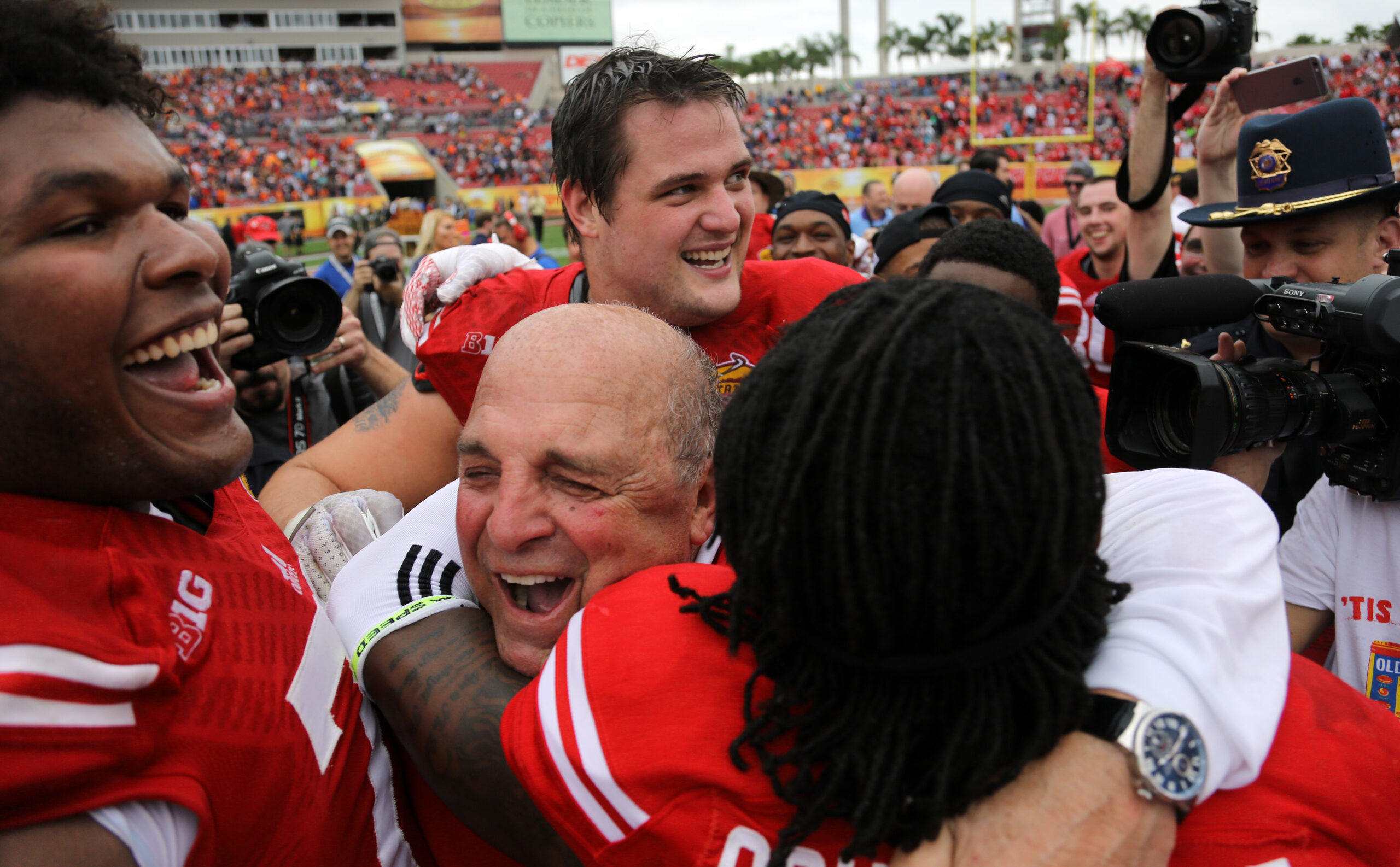 Barry Alvarez hugs a player after a win at the Outback Bowl
