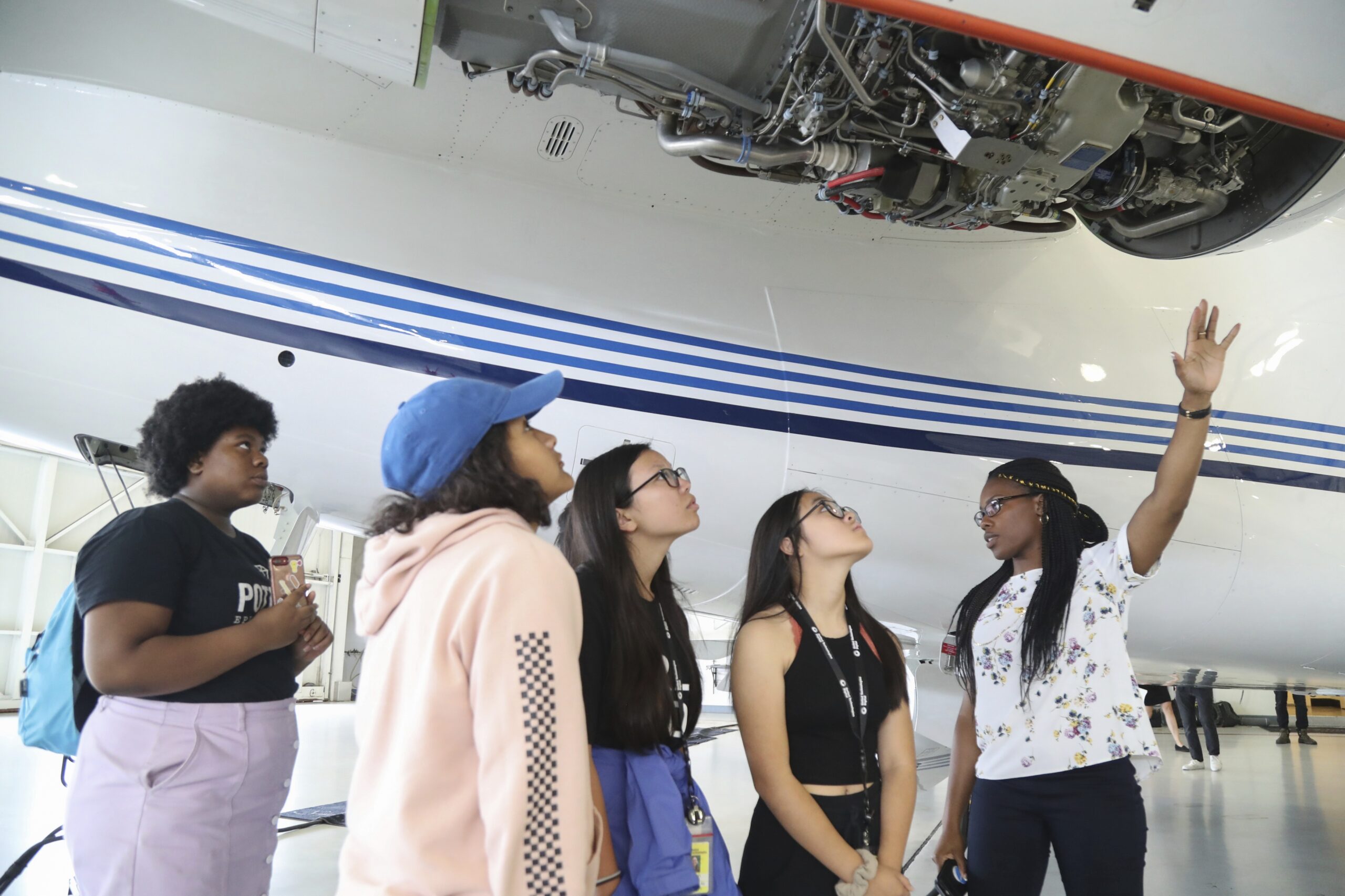 Girls looking at an airplane engine