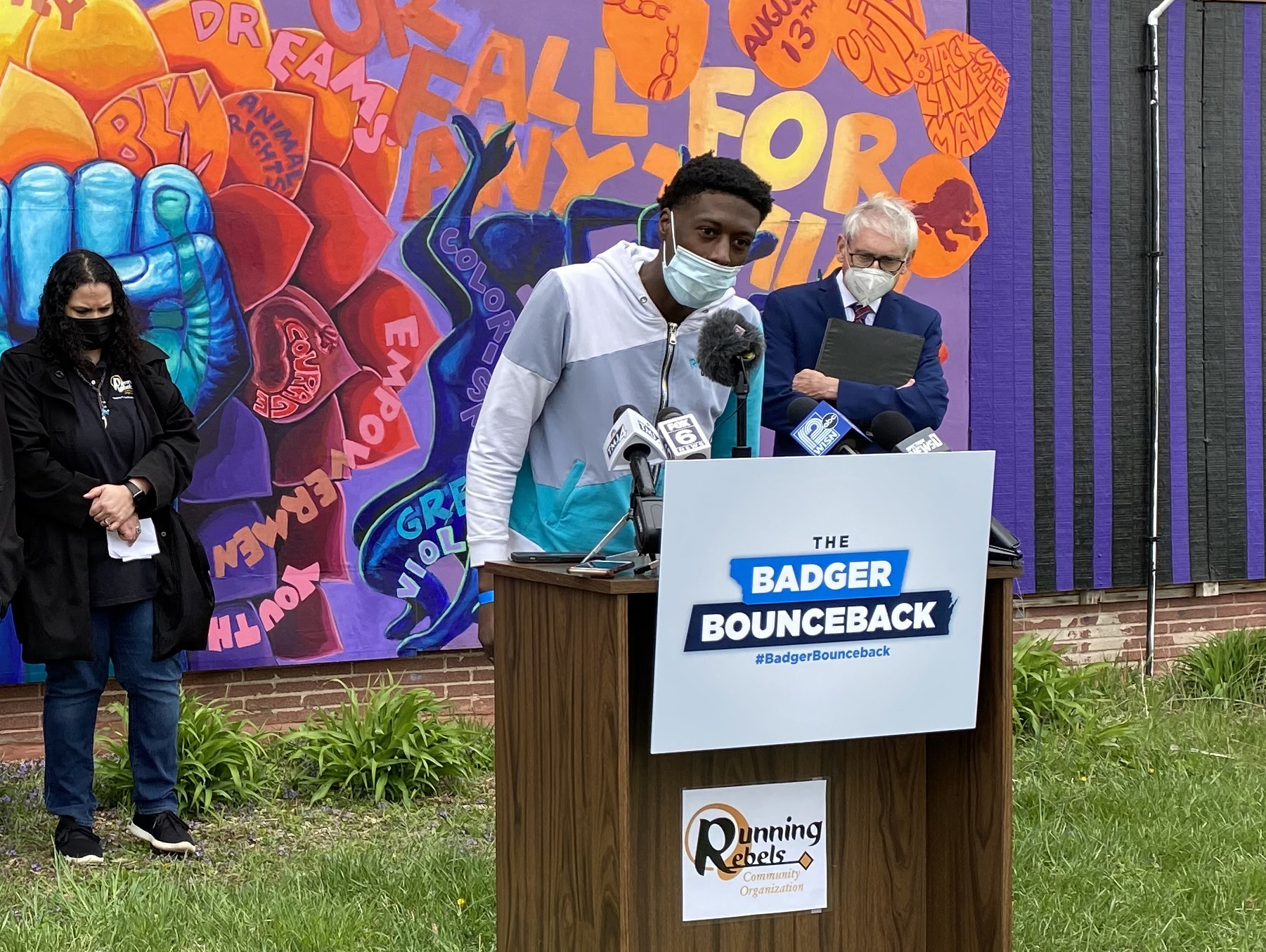 A young man speaks at a podium outdoors