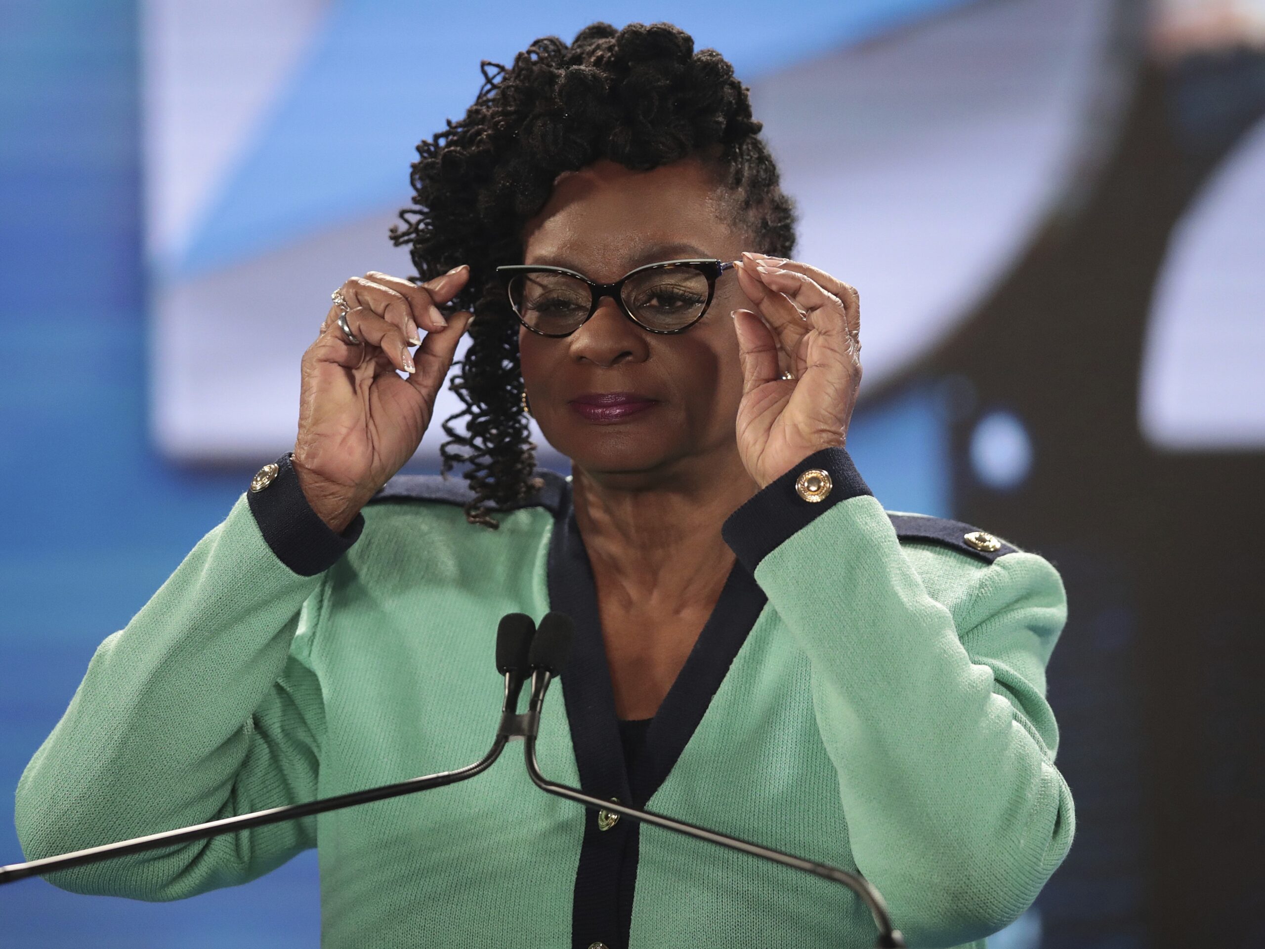 Representative Gwen Moore adjusts her glasses at the podium at the 2020 DNC