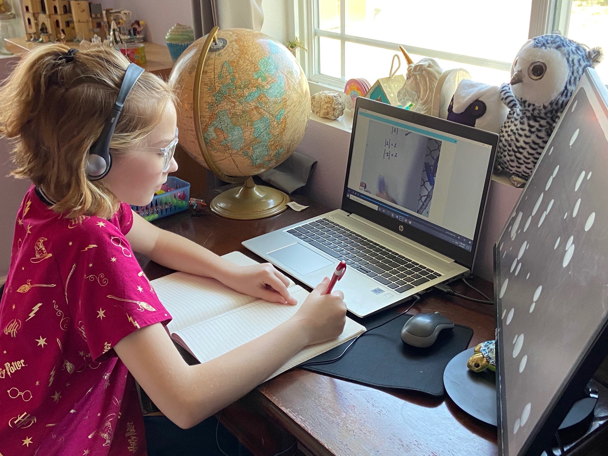 A girl works on a math assignment while looking at a screen