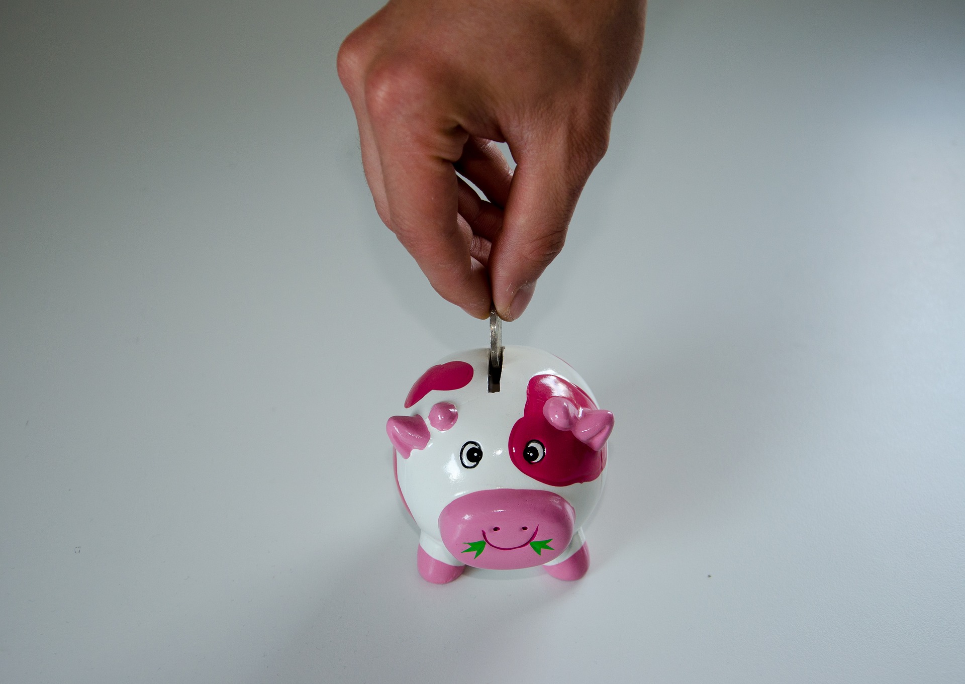 Putting coins in a piggy bank.