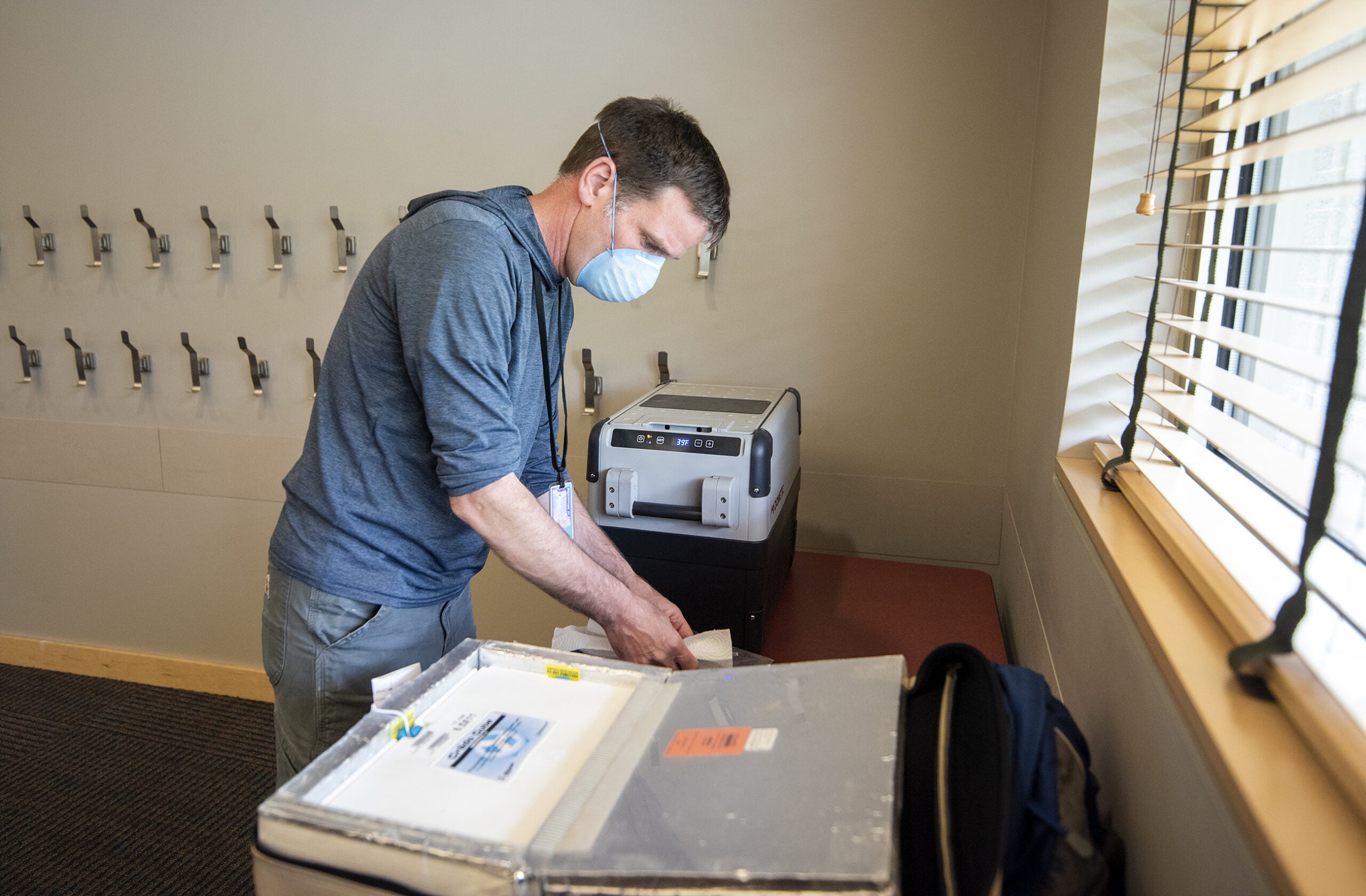 Nick Tomaro works while wearing a face mask.