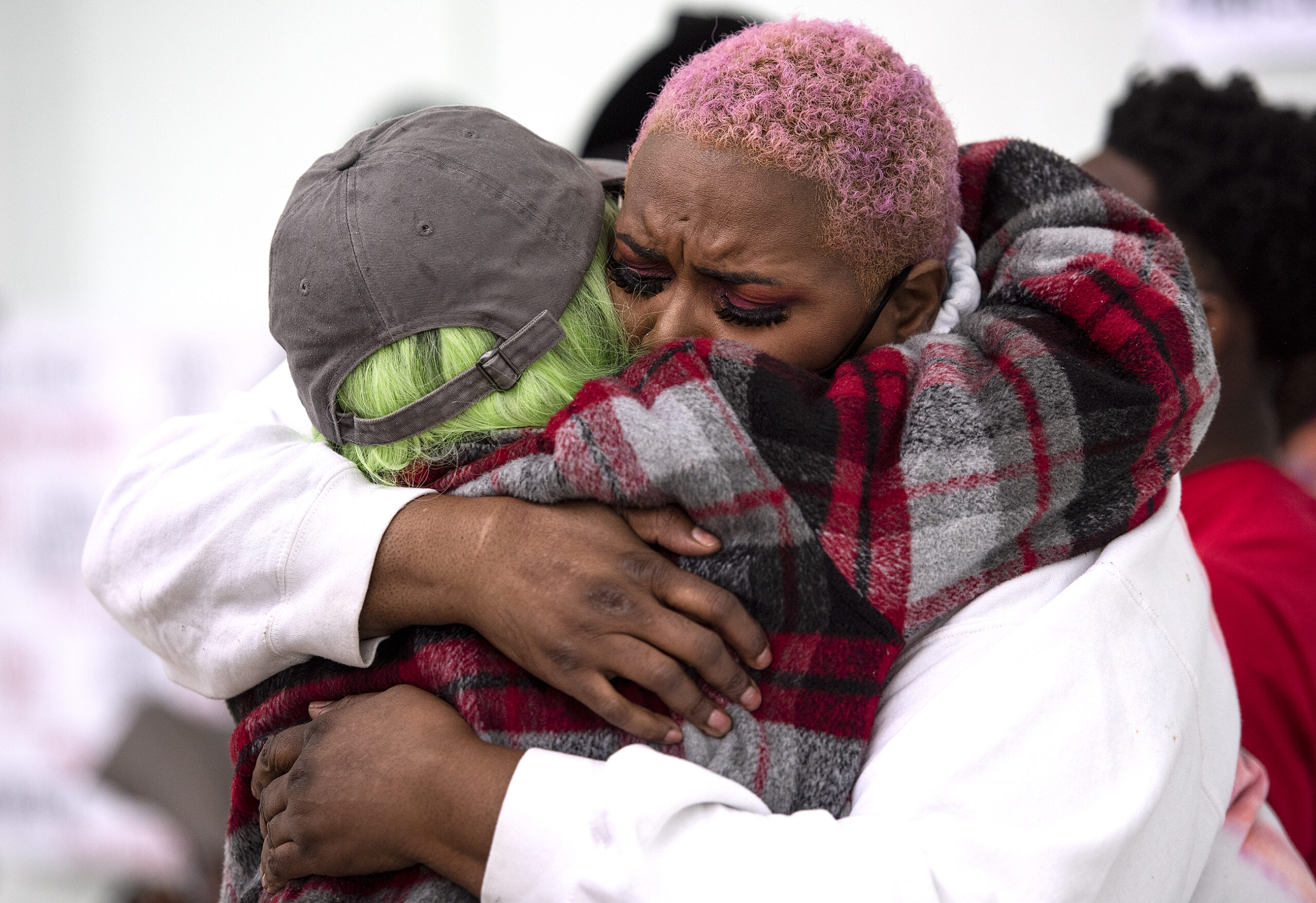 Two women embrace after sharing emotional speeches.