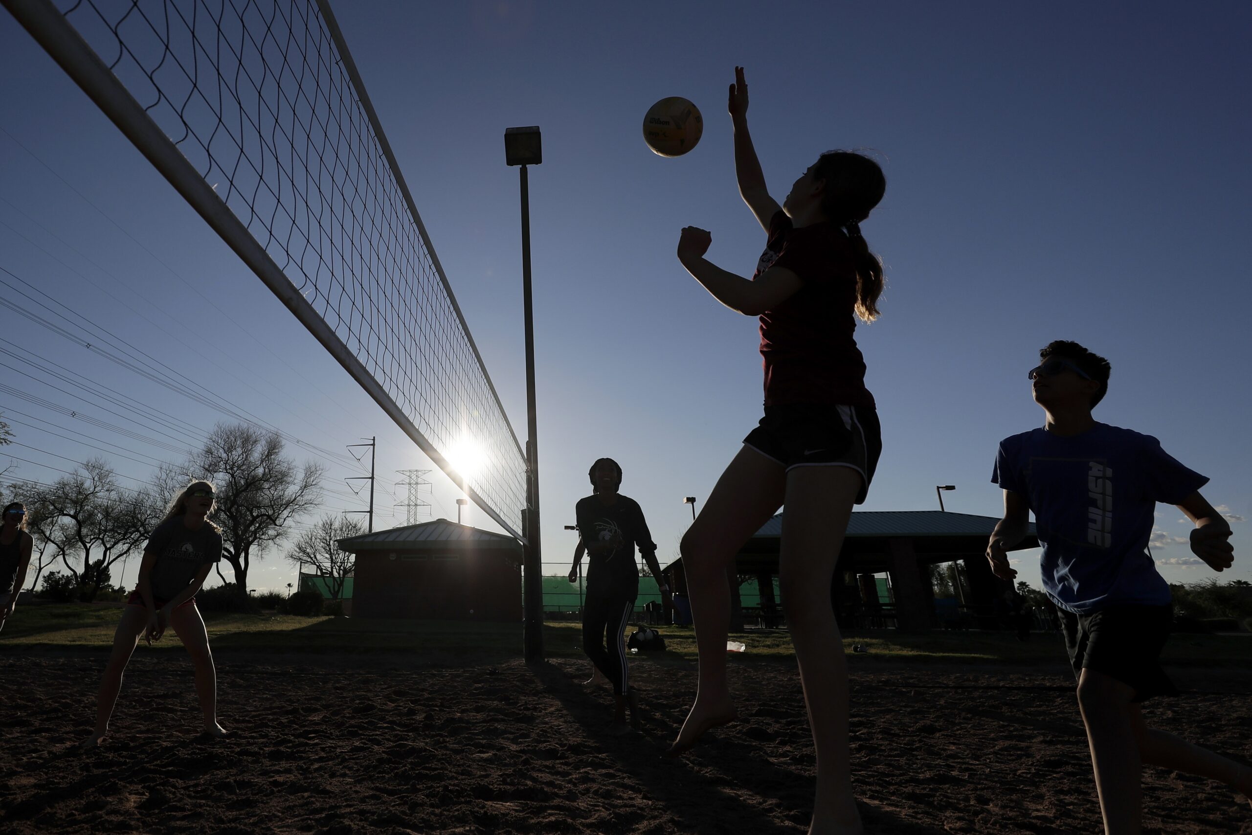 Friends gather to play volleyball at a local park during the coronavirus pandemic