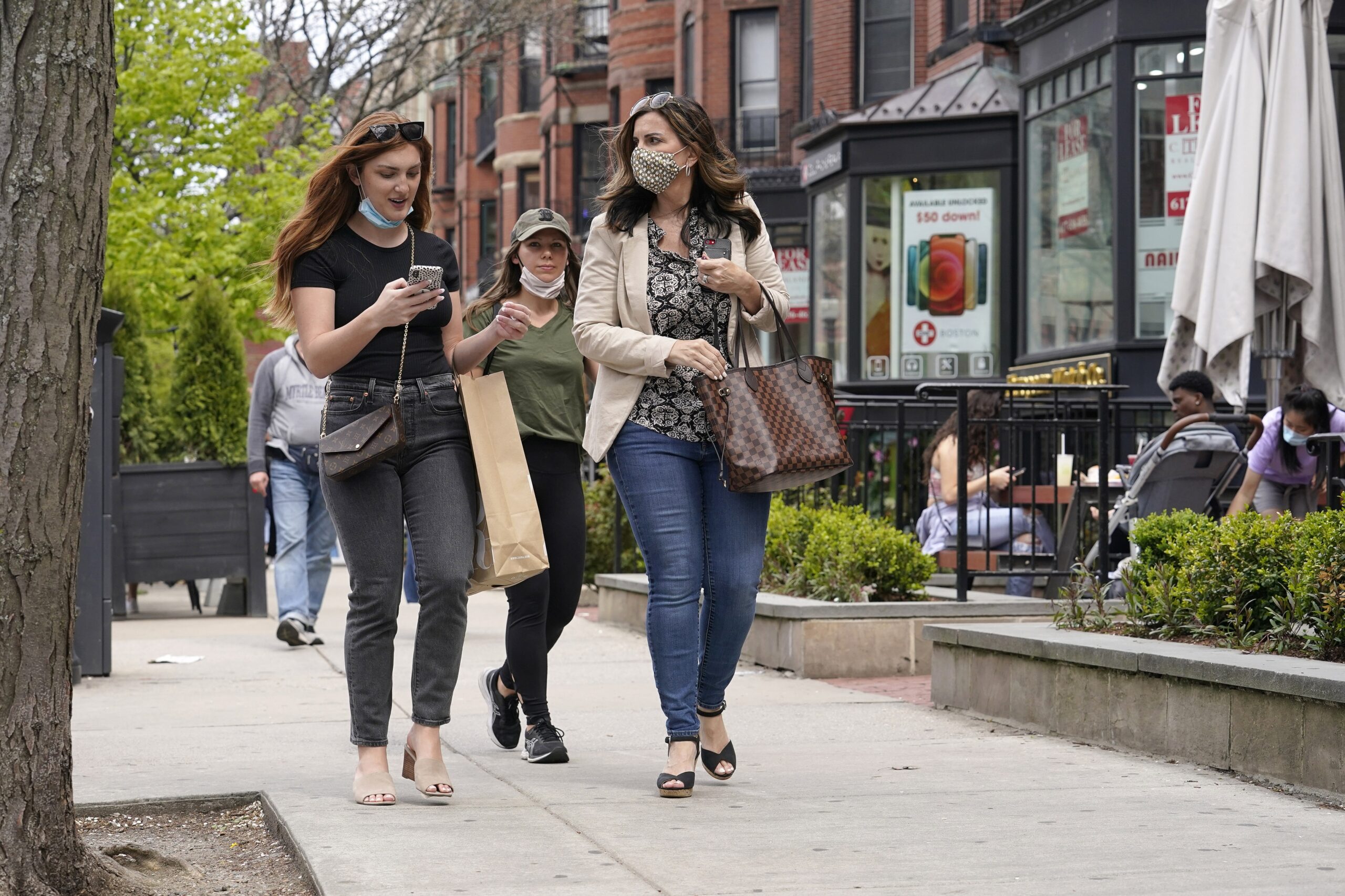 Pedestrians walk along Boston's fashionable Newbury Street