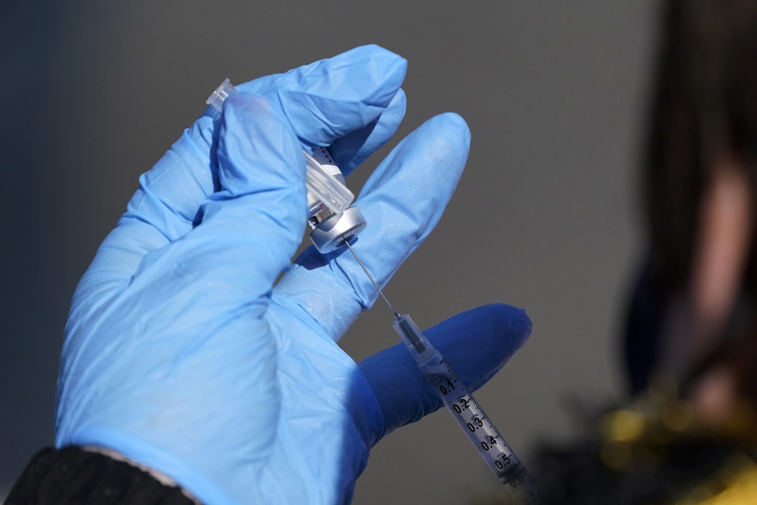 A nurse fills a syringe with COVID-19 vaccine