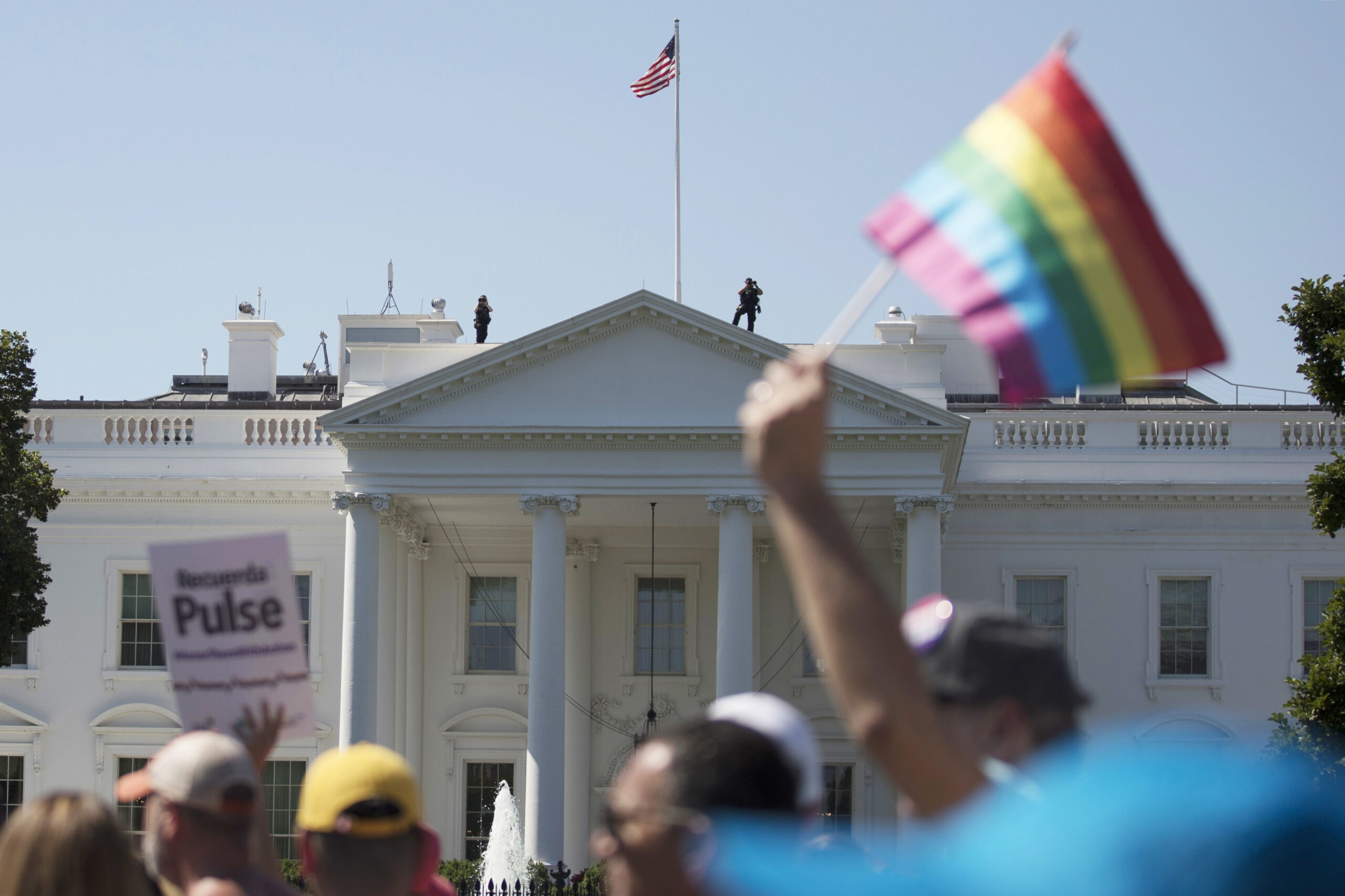 Equality March for Unity and Pride participants march past the White House in Washington