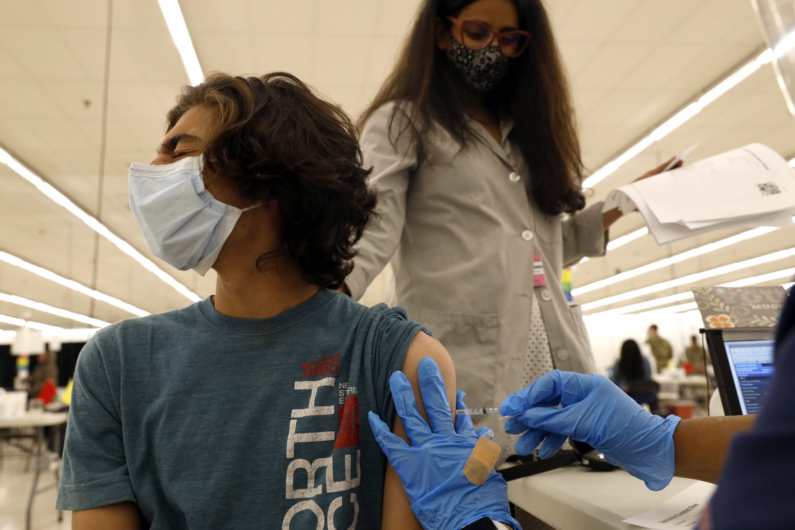 Kieran Layland, 15, receives his first Pfizer COVID-19 vaccination.