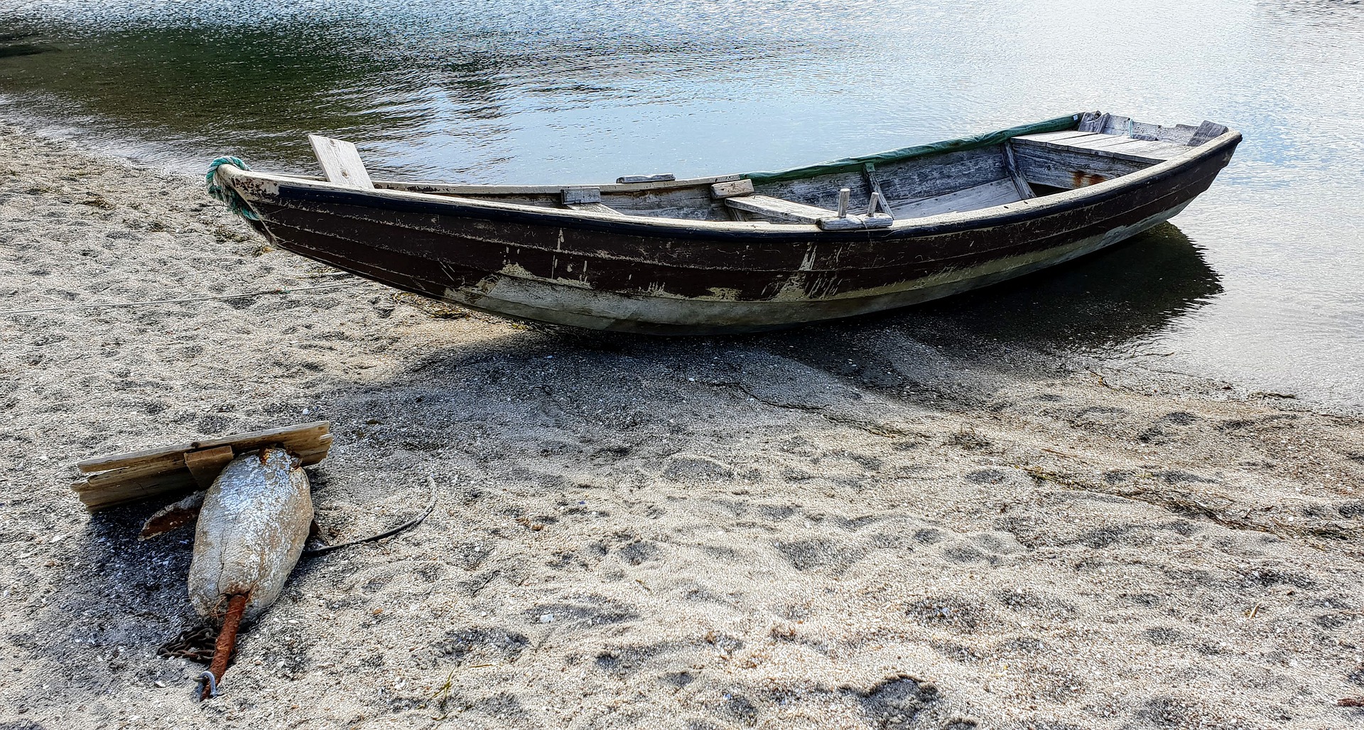 Old rowboat on sandy beach.