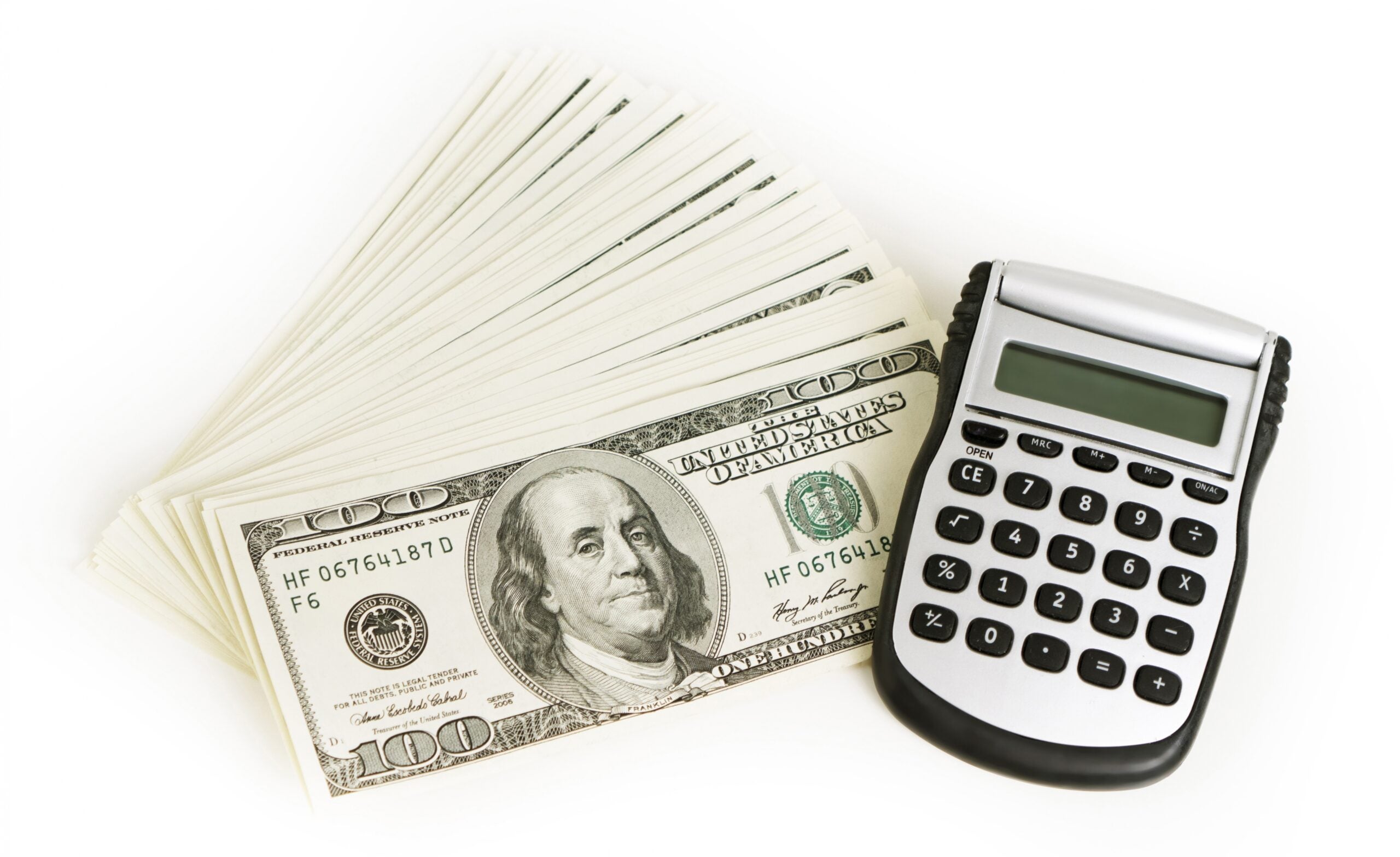 A pile of money including a hundred dollar bill and a calculator.