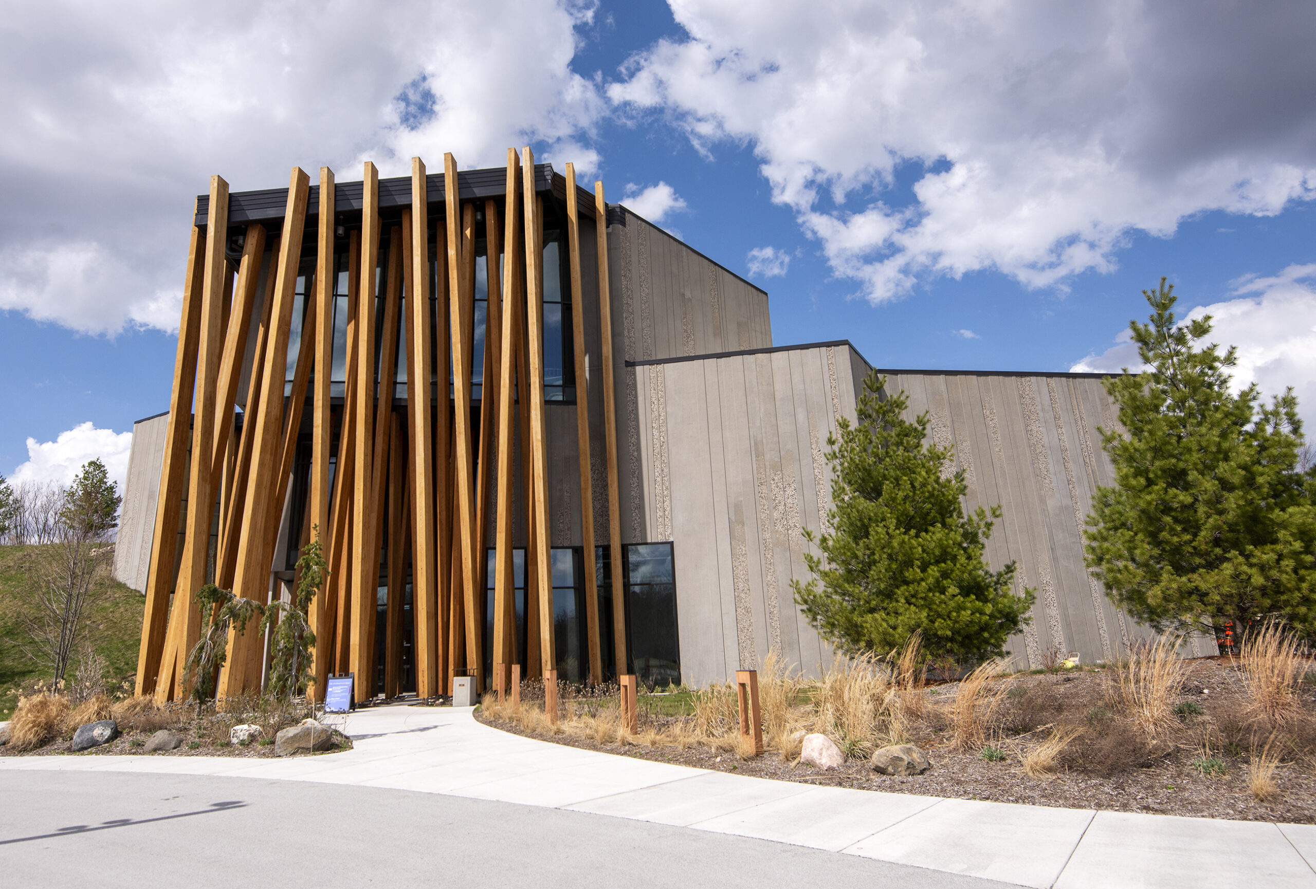 Large wooden beams are the front facade of a modern museum building.