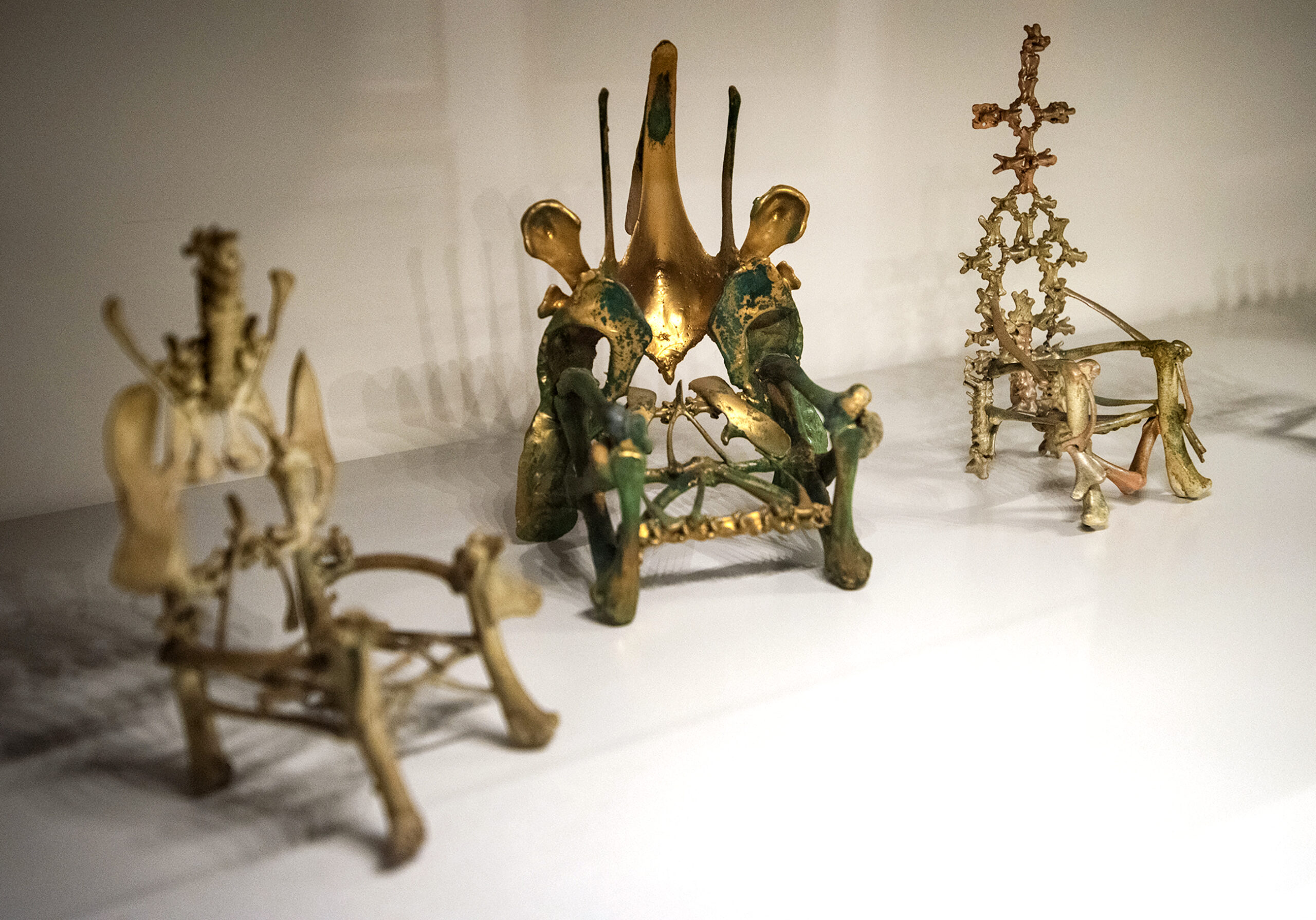 Green and gold painted miniature thrones made of poultry bones.