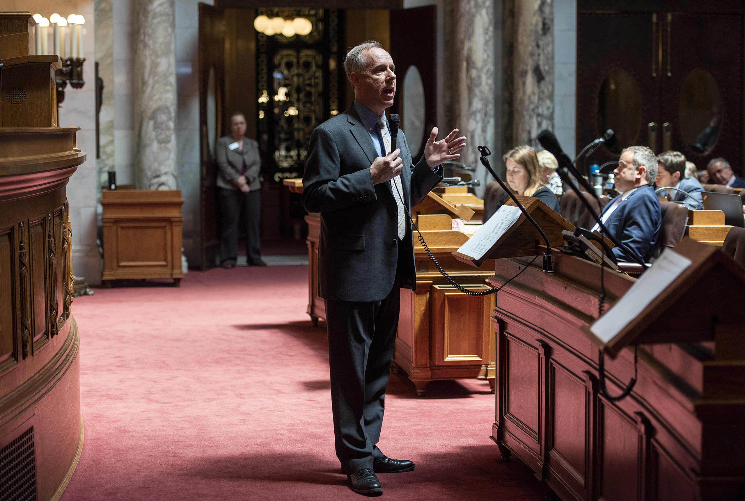 Assembly Speaker Robin Vos stands on red carpet as he speaks at the front of the chamber.