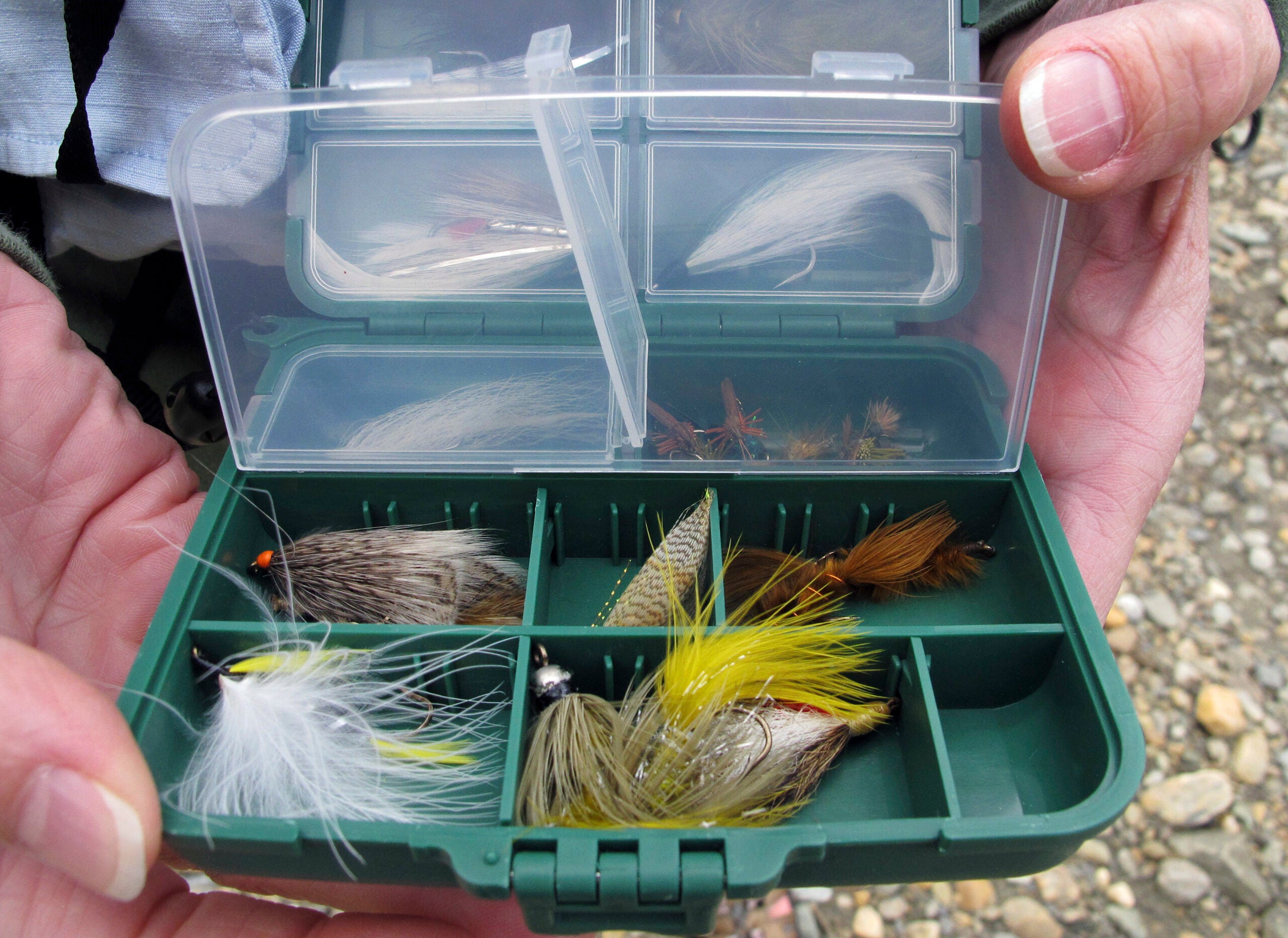 A fly fishing guide displays a box of flies during a fly fishing retreat