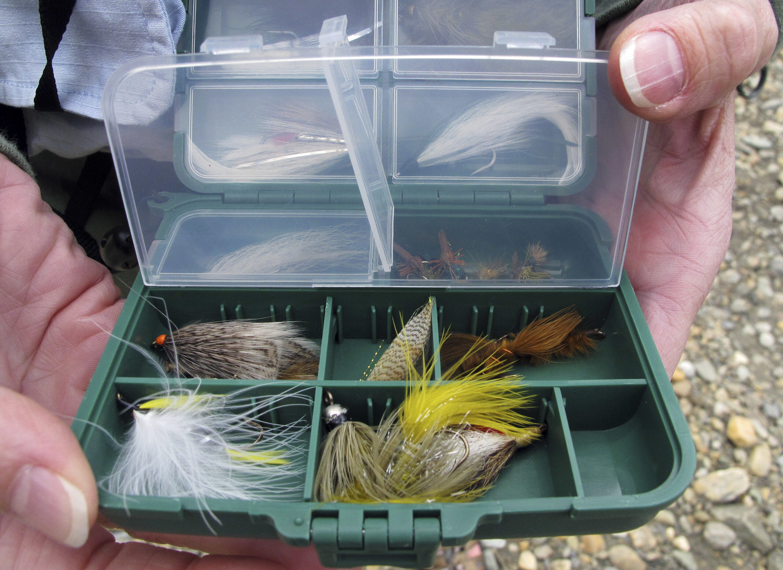 A fly fishing guide displays a box of flies during a fly fishing retreat