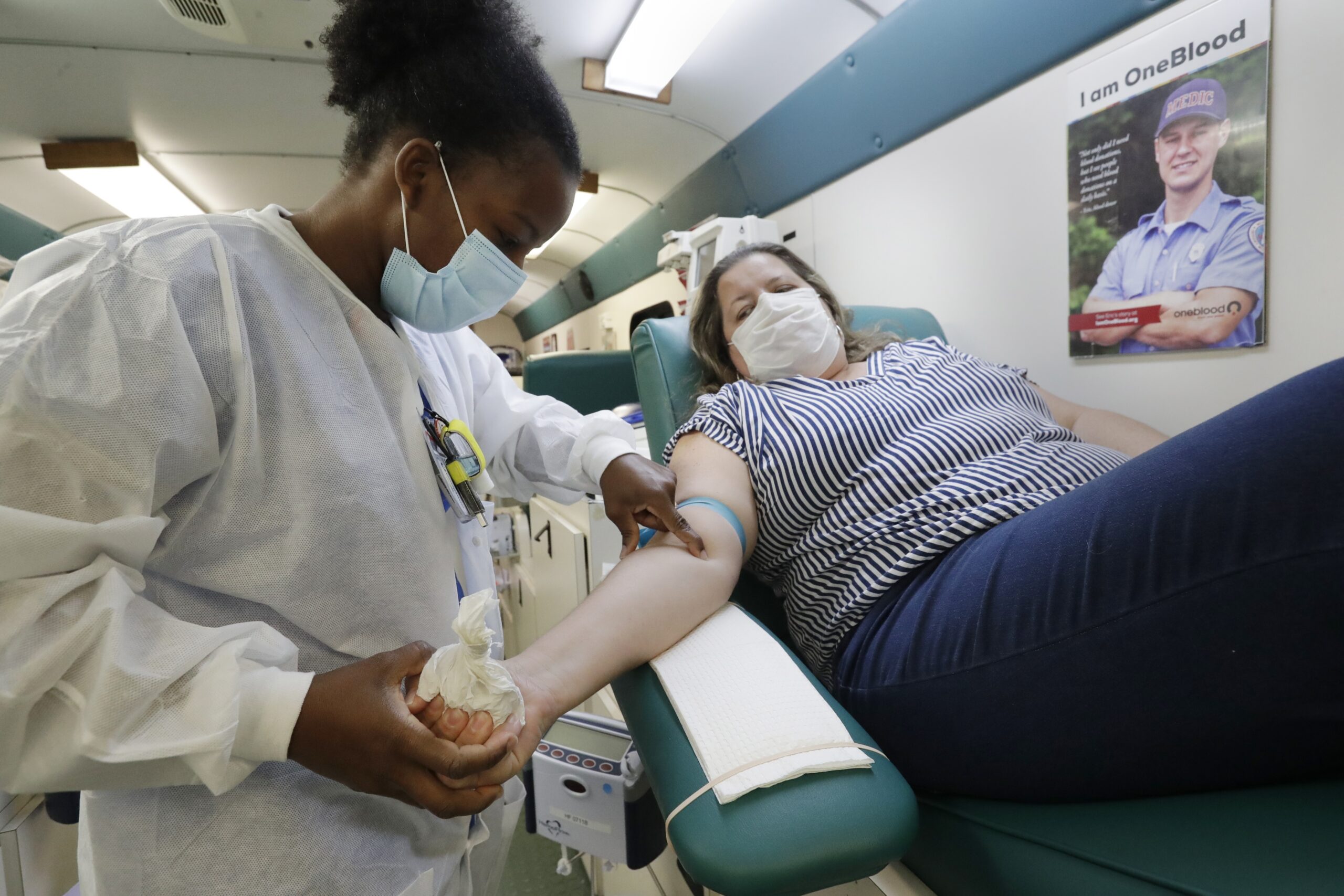 Phlebotomist Josianne Fiefie looks for a vein as Maria Teresa Andreychuk prepares to donate blood