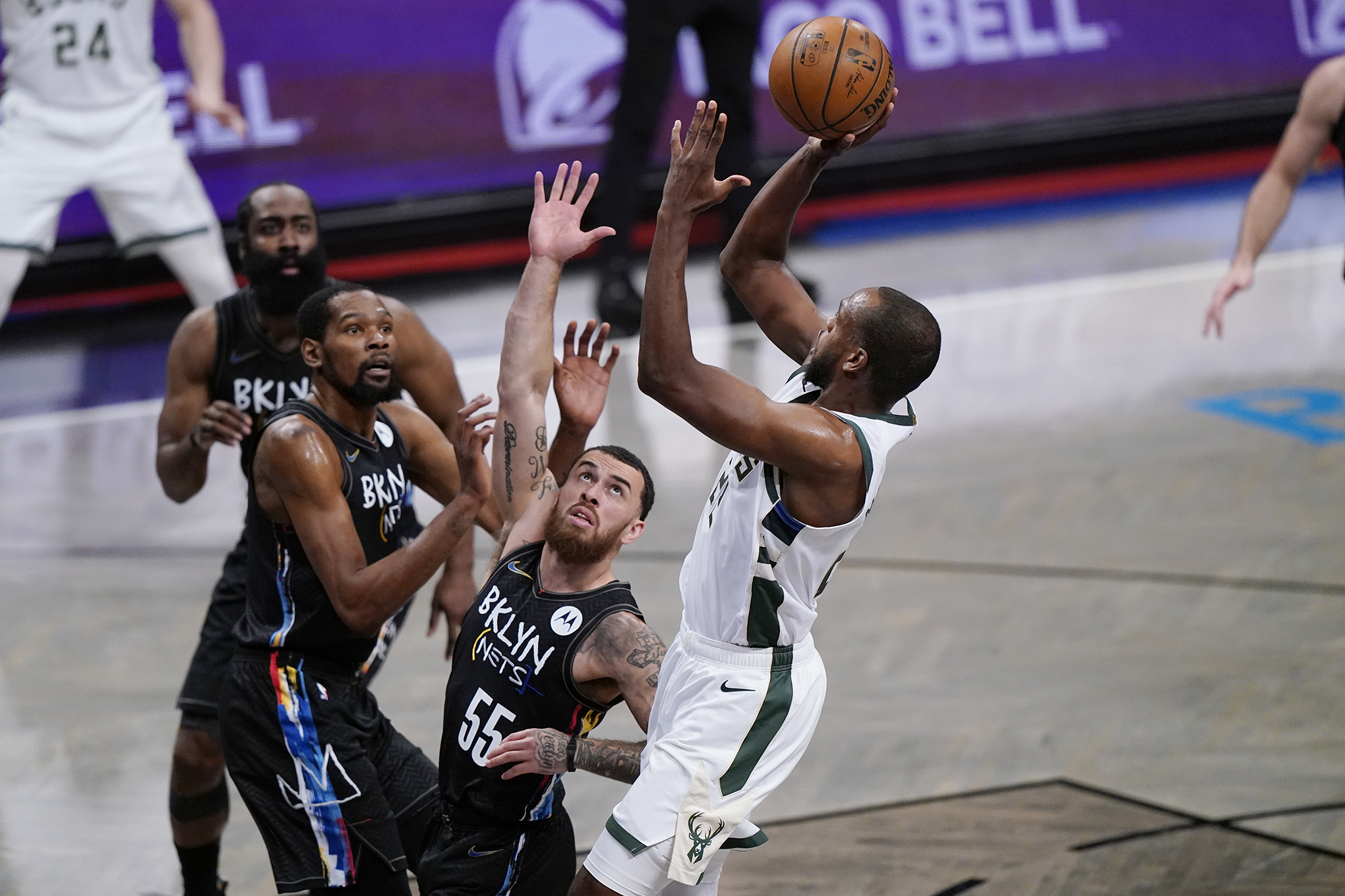Nets Mike James defends Bucks forward Khris Middleton as he goes up for a layup