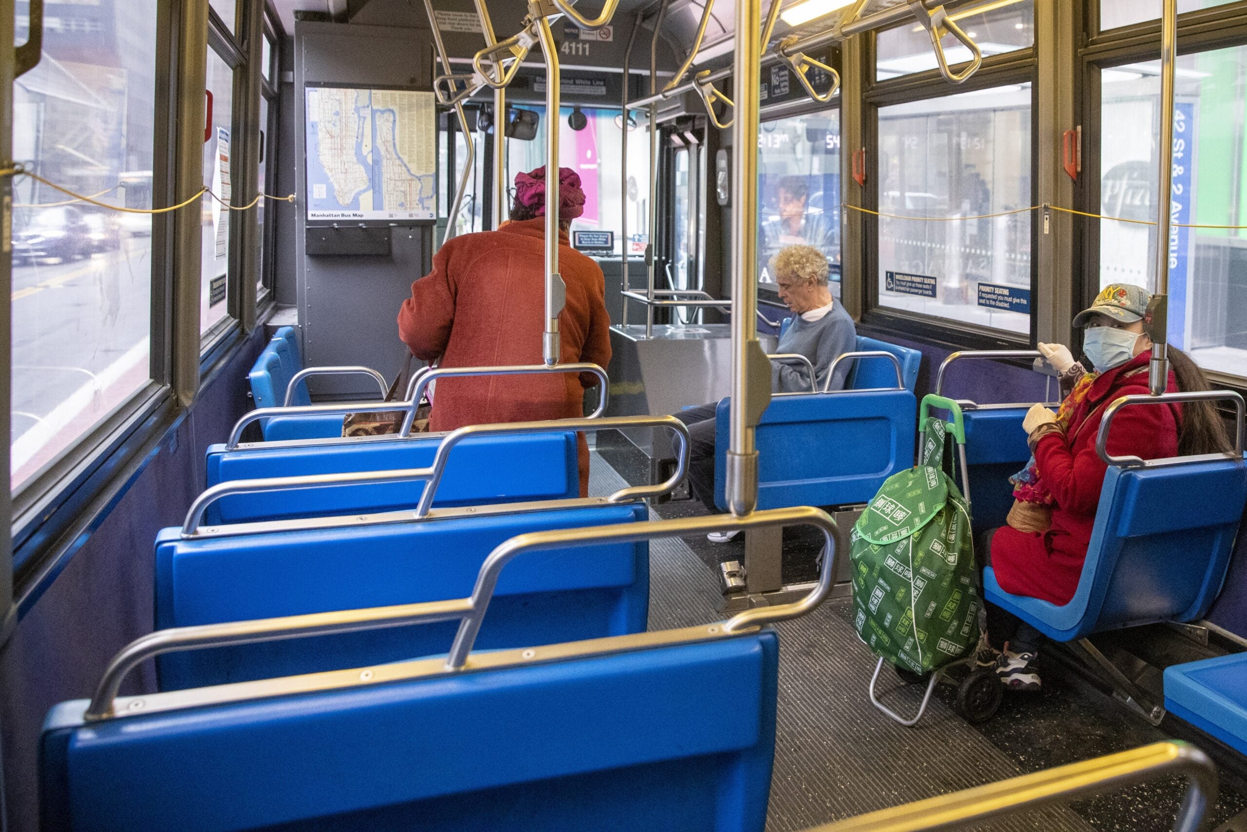 A woman wears a face mask as she rides the bus