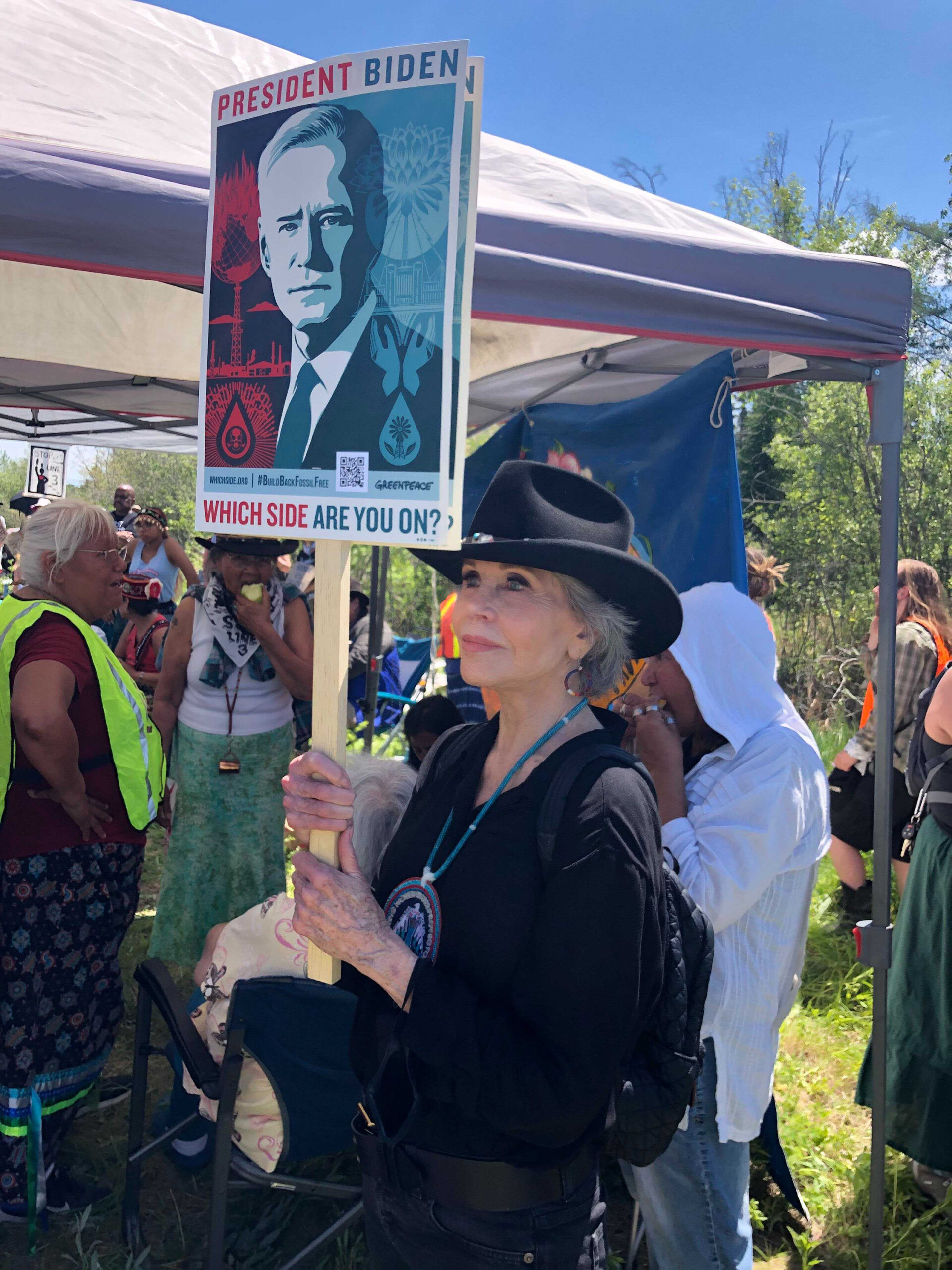 Jane Fonda holds a sign with a picture of Joe Biden