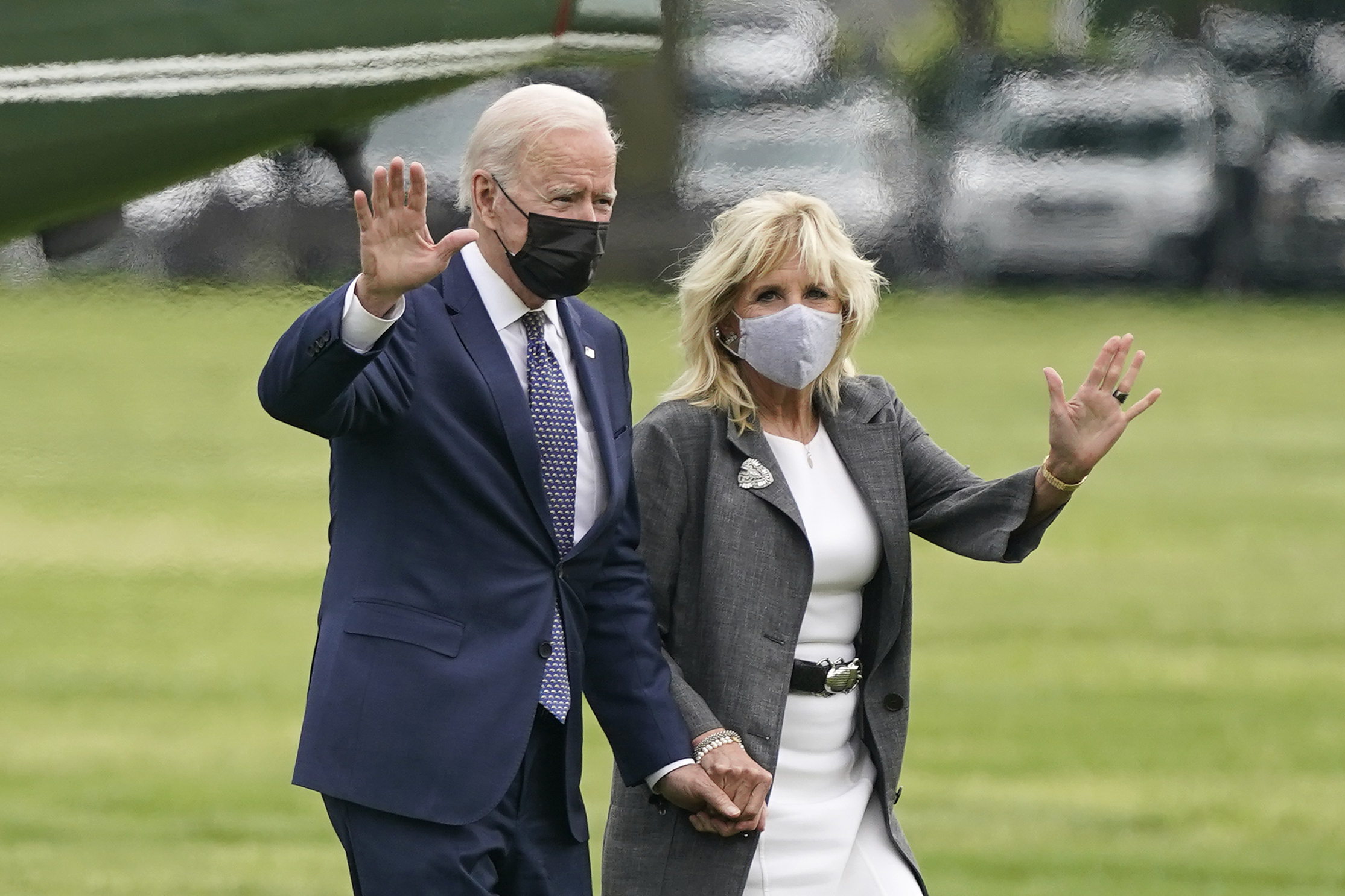 President Joe Biden and First Lady Jill Biden wave while wearing masks