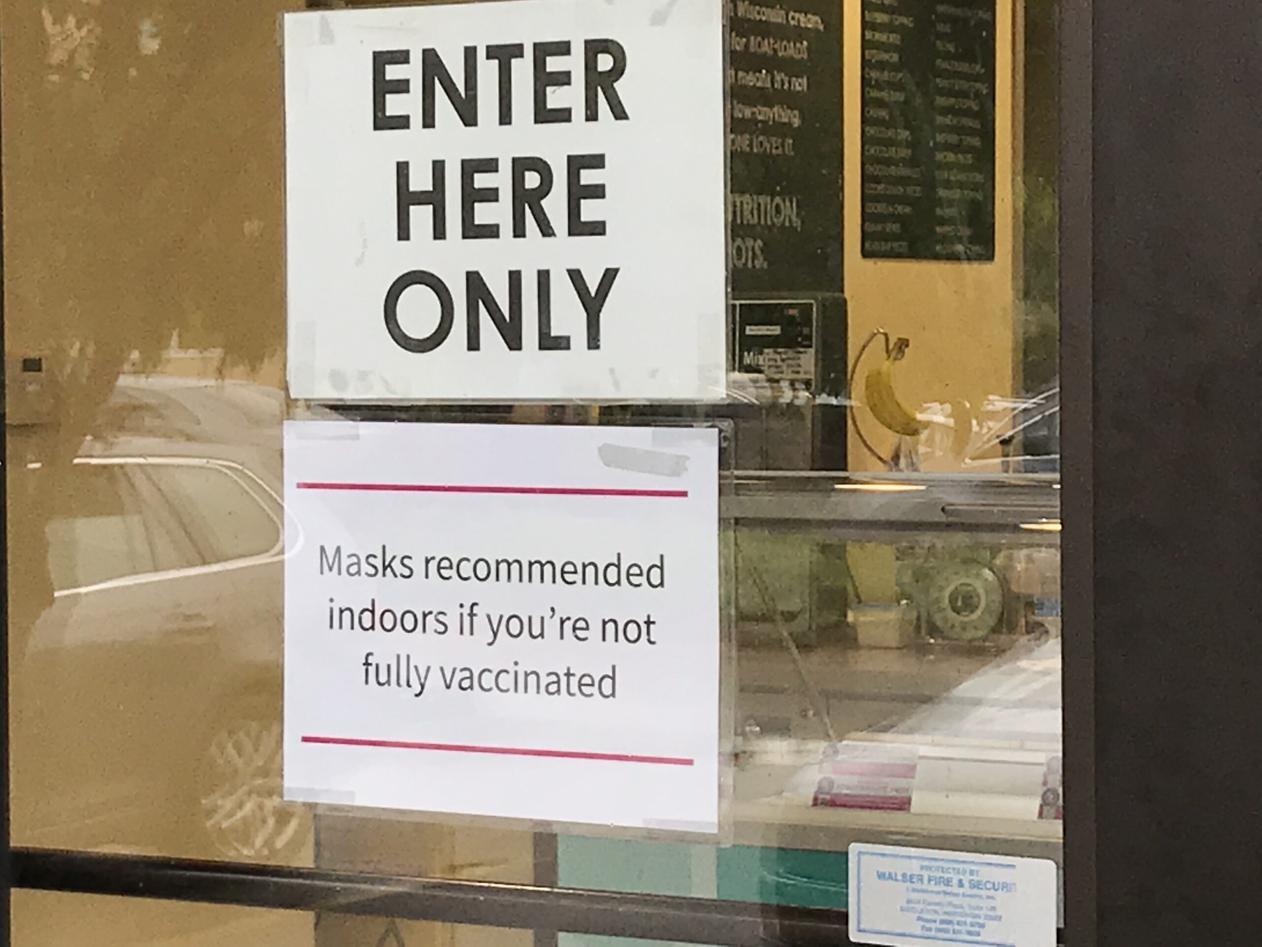 A sign asking customers to wear masks in a local shop