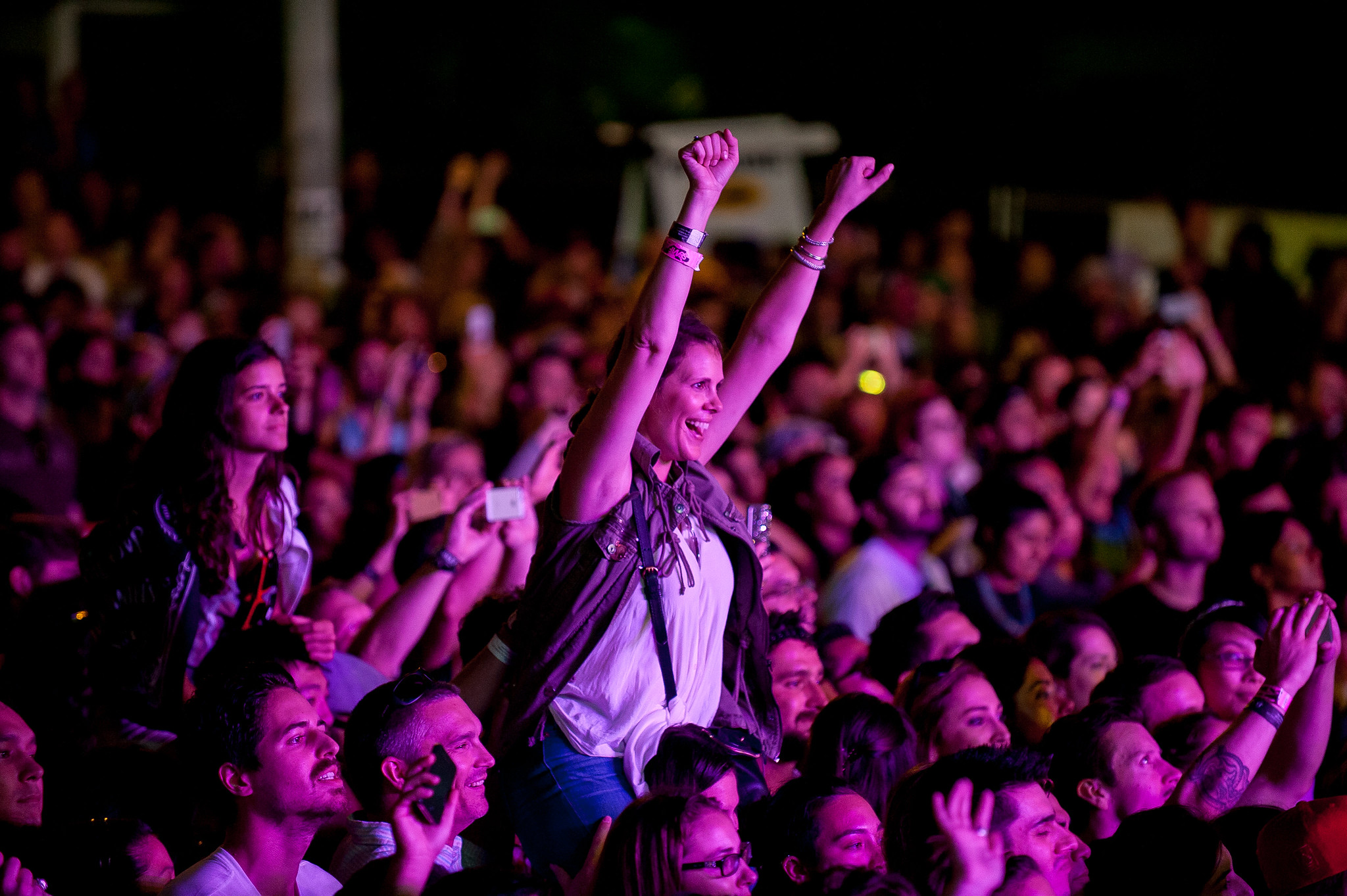 crowd cheers at a music festival at night