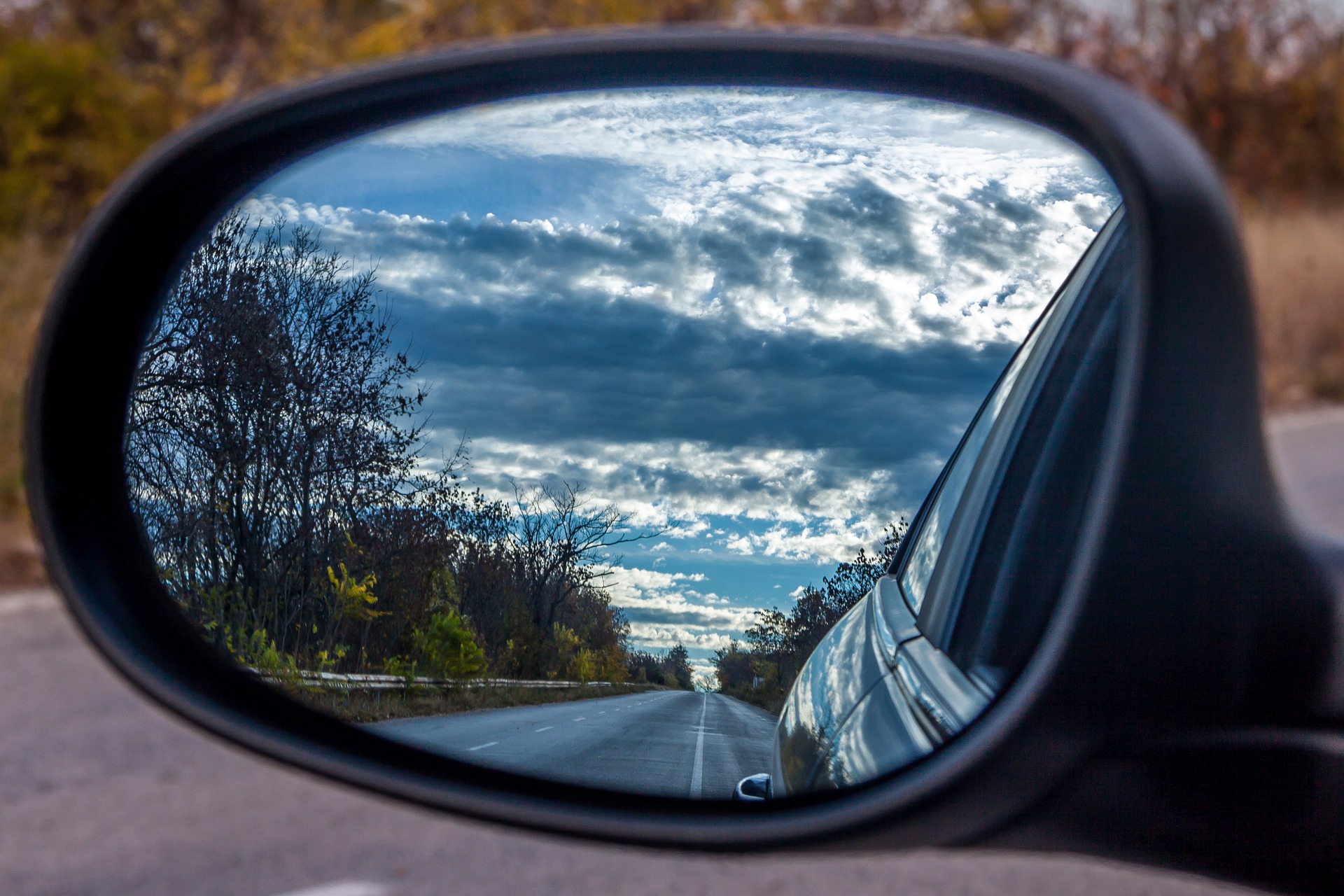 Road reflected in side mirror.