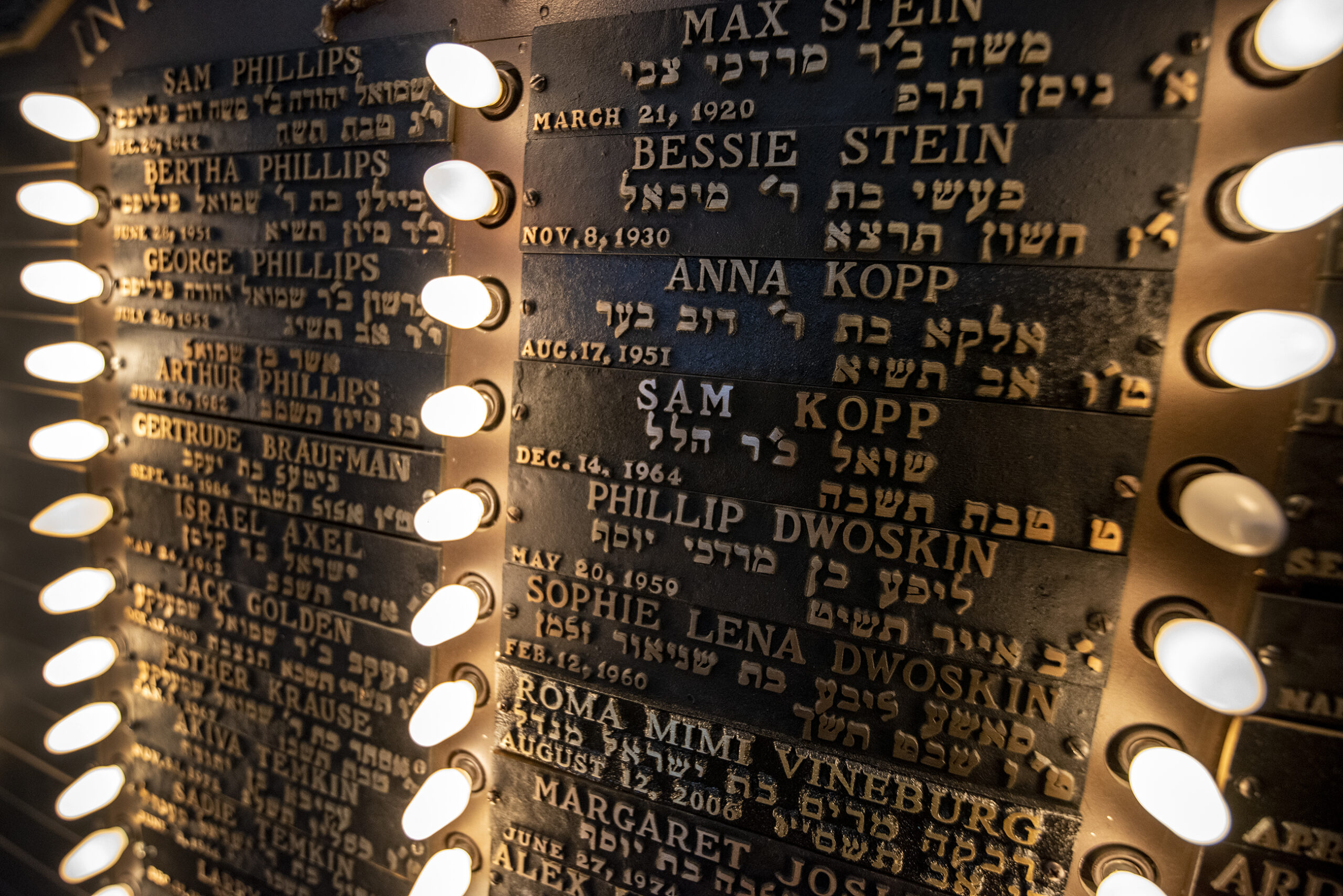 small lights illuminate names written in gold text on a plaque.