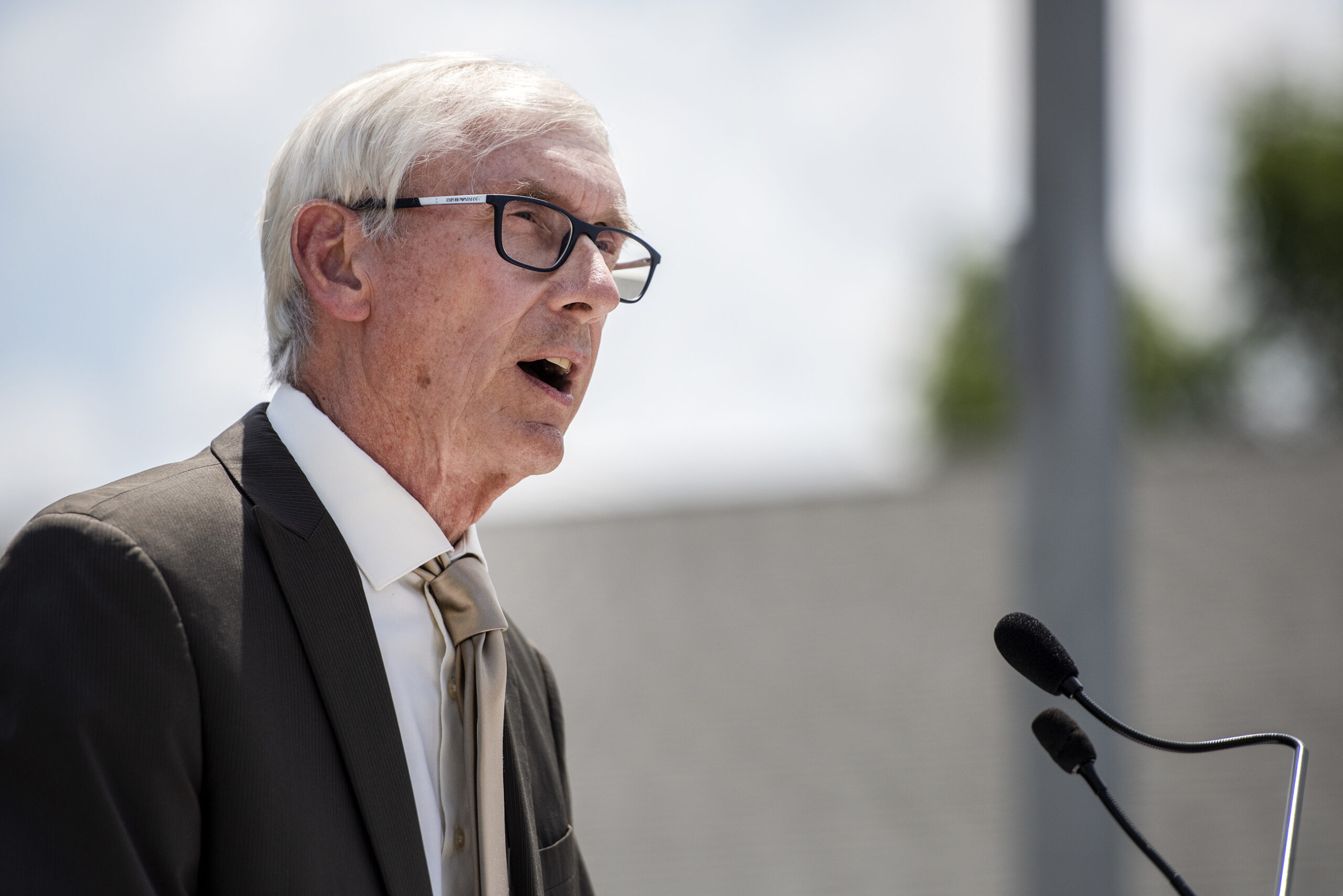 The sky can be seen behind Tony Evers as he speaks during a press conference.