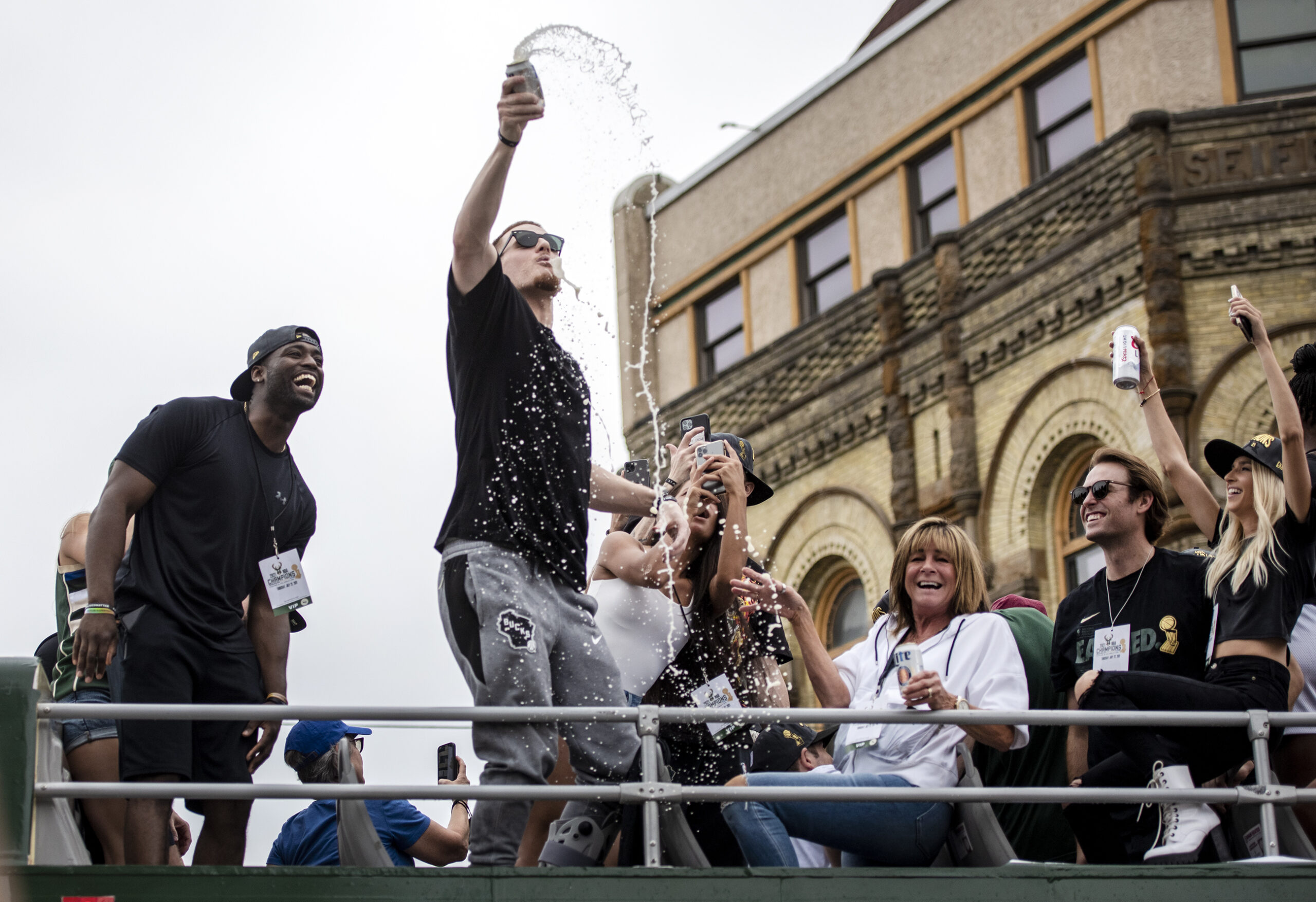 Donte DiVencenzo shotguns a beer on top of a bus.