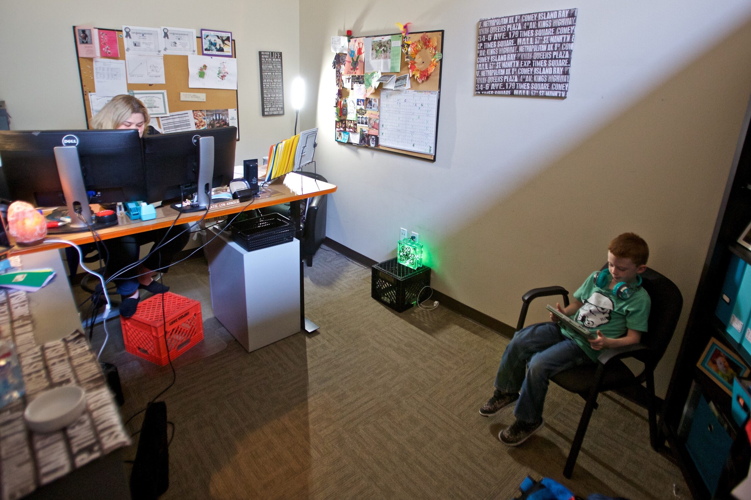 atie Arnold works while her son Rowen Arnold plays educational games on her iPad