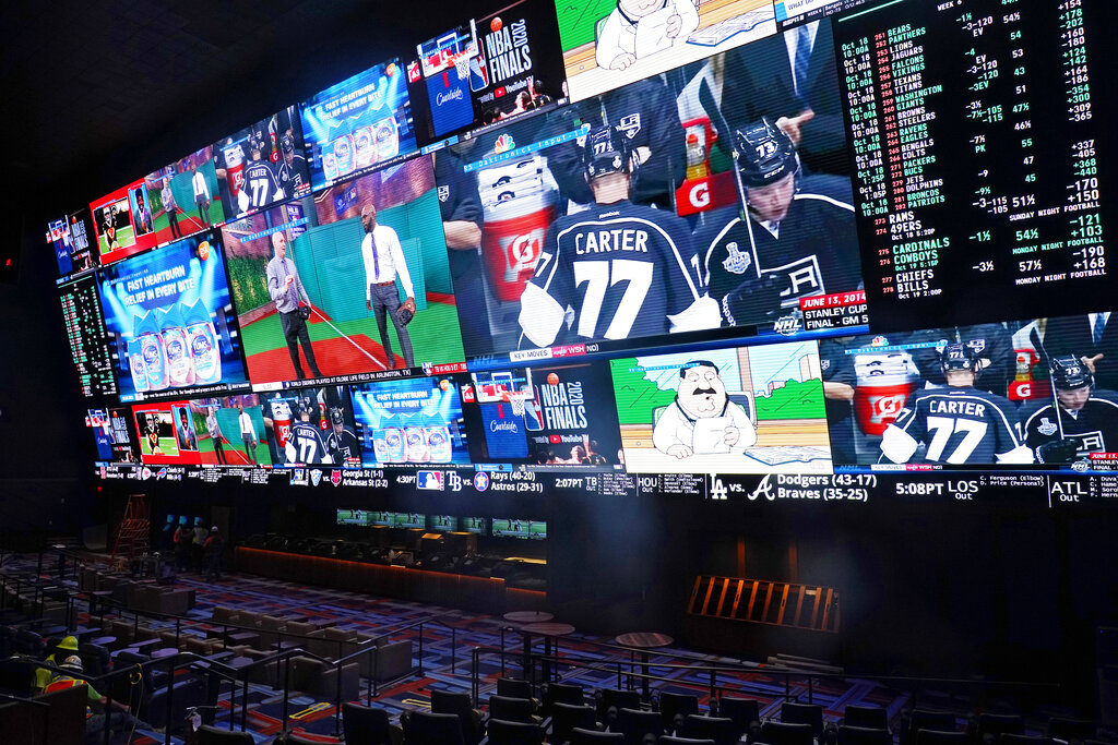 Screens show sports and betting odds in the sports book as workers finish work at the Circa Resort & Casino