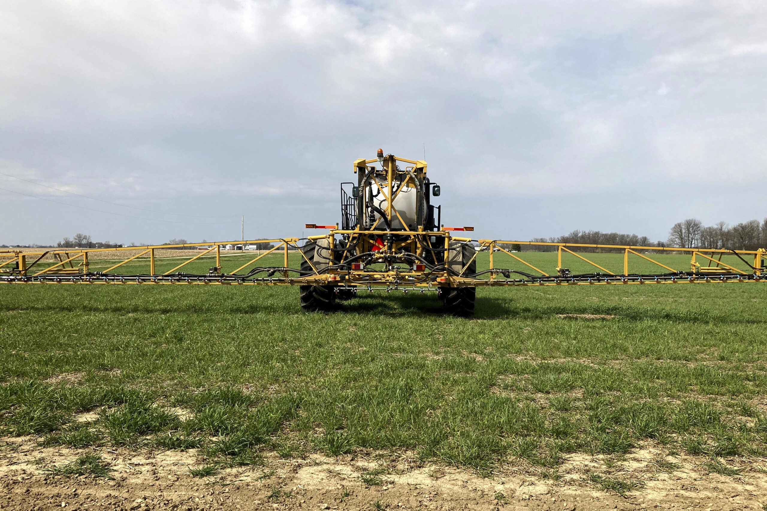 Farmer Rick Clifton drives a spray tractor across one of his fields