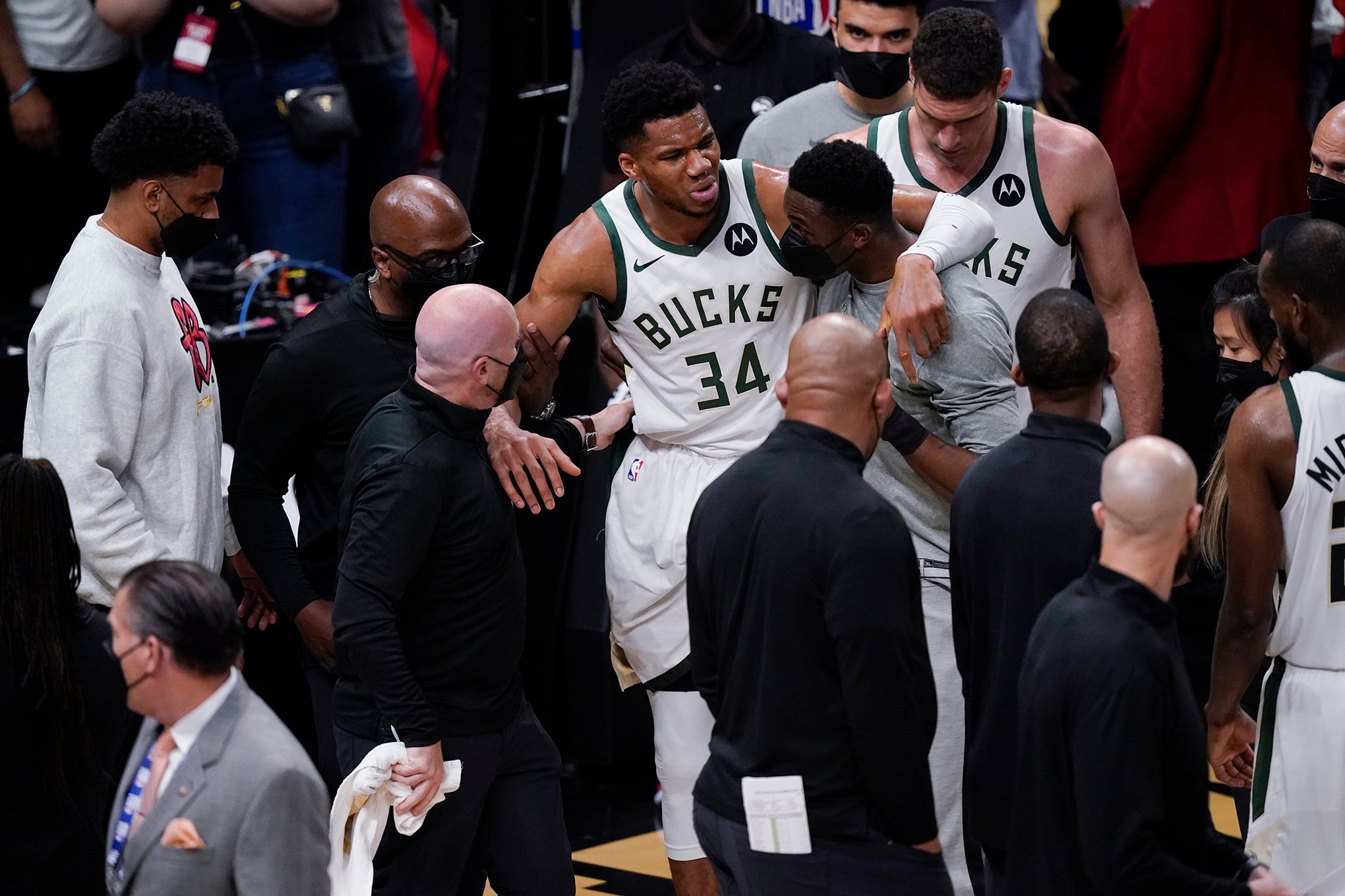 Milwaukee Bucks' Giannis Antetokounmpo is helped off the court.