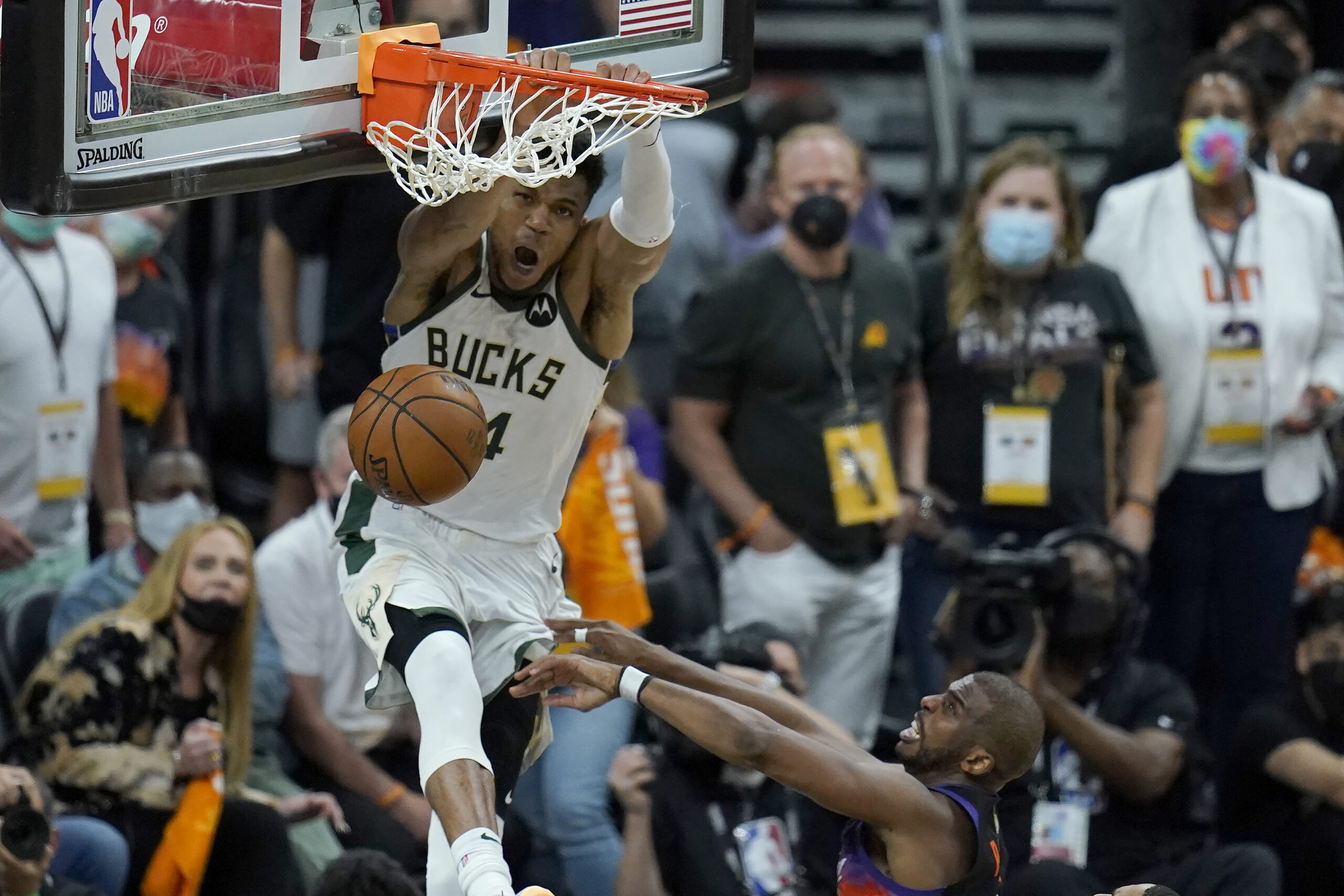 Milwaukee Bucks forward Giannis Antetokounmpo dunks over Phoenix Suns guard Chris Paul