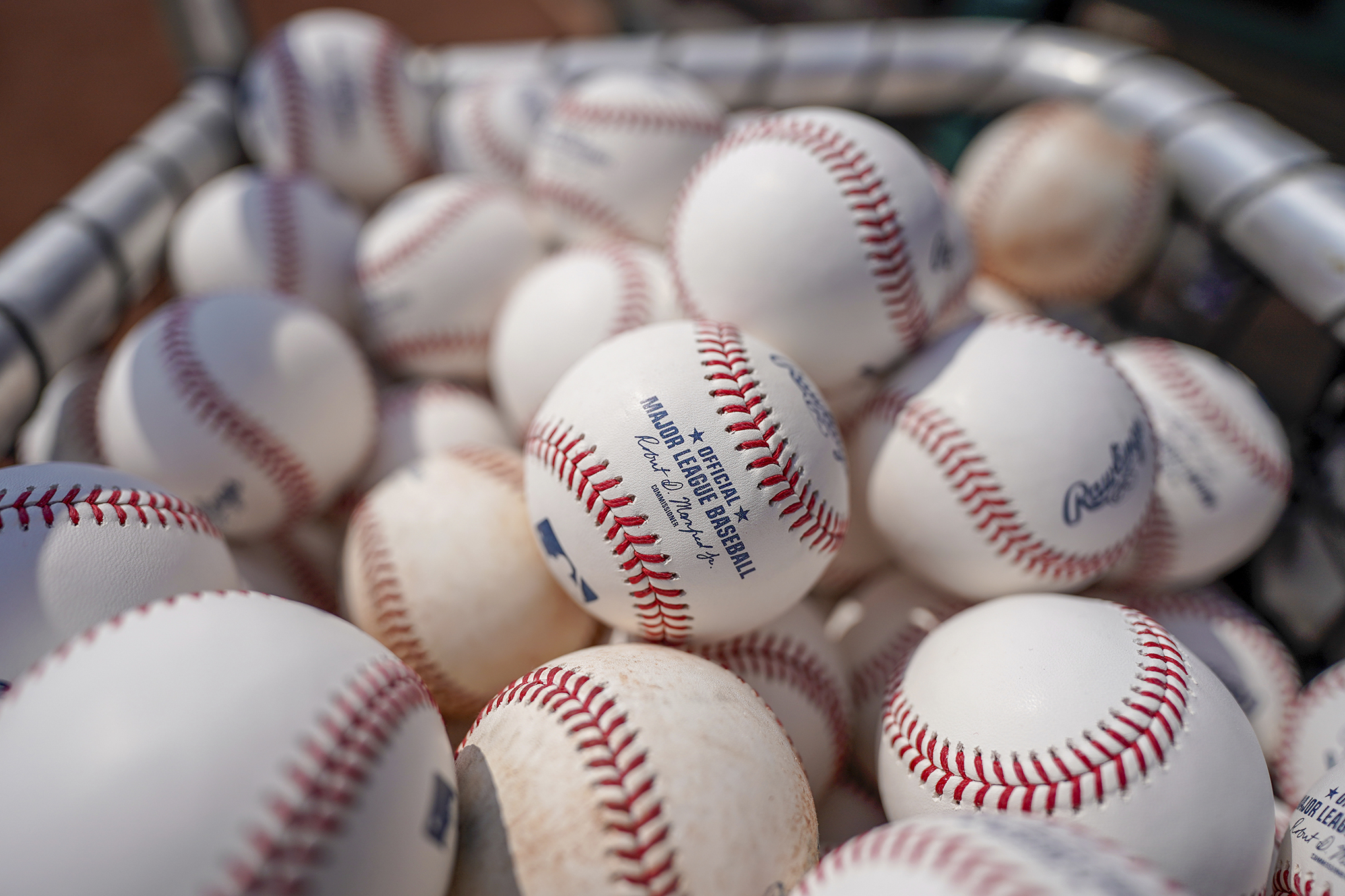 Baseballs are held in a basket on the field before the Cincinnati Reds played the Milwaukee Brewers