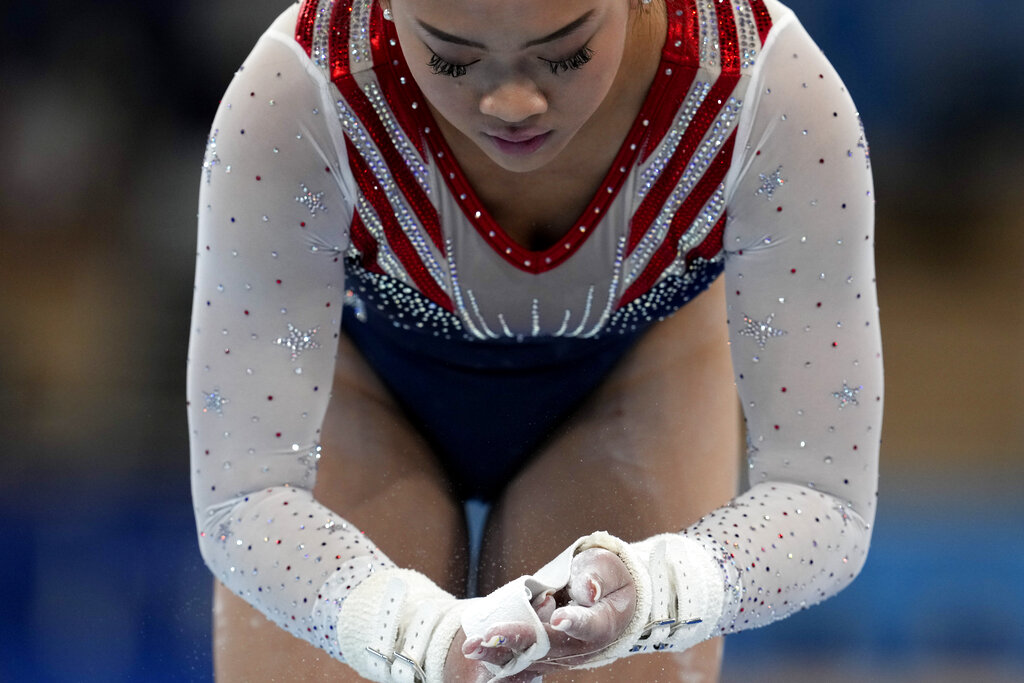 Sunisa Lee powders her hands before her performance on the uneven bars during the artistic gymnastics women's all-around final at the 2020 Summer Olympics