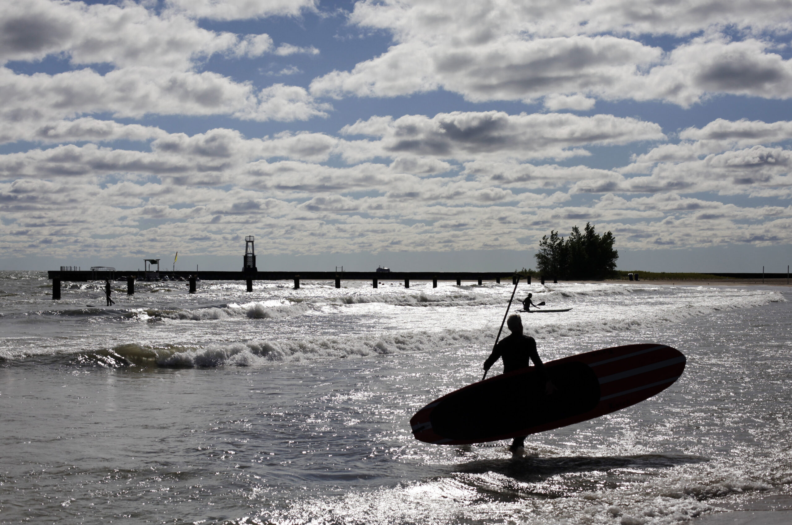 Paddle boarders try to catch some waves on Lake Michigan