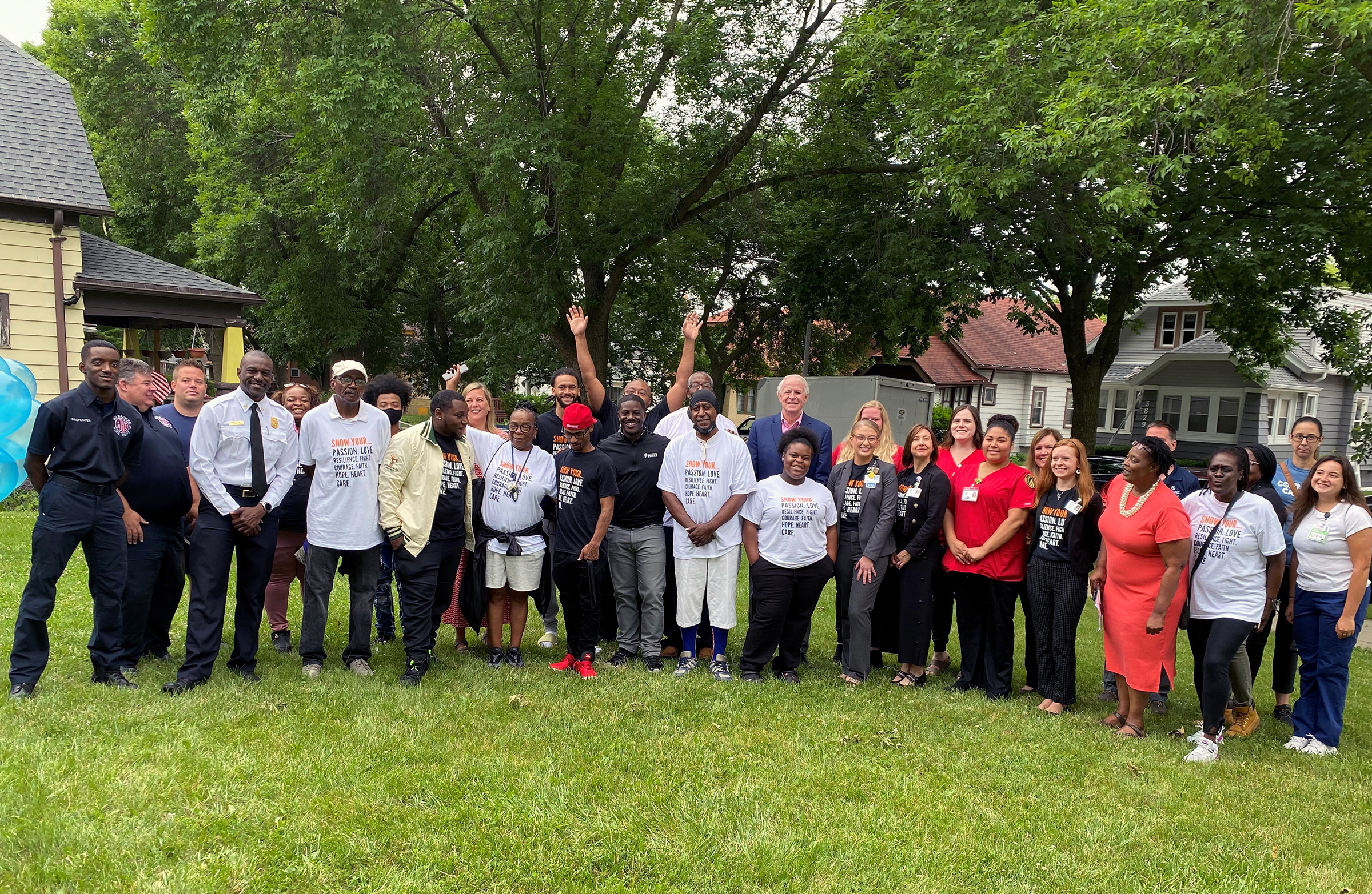 A group of volunteers stands on a lawn