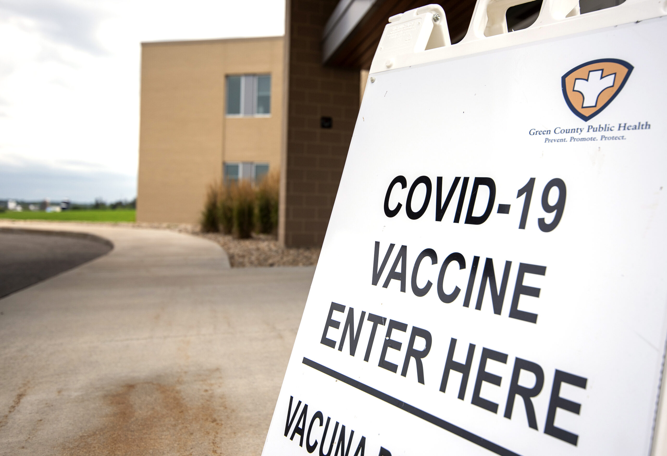 A white sign says "COVID-19 VACCINE ENTER HERE."