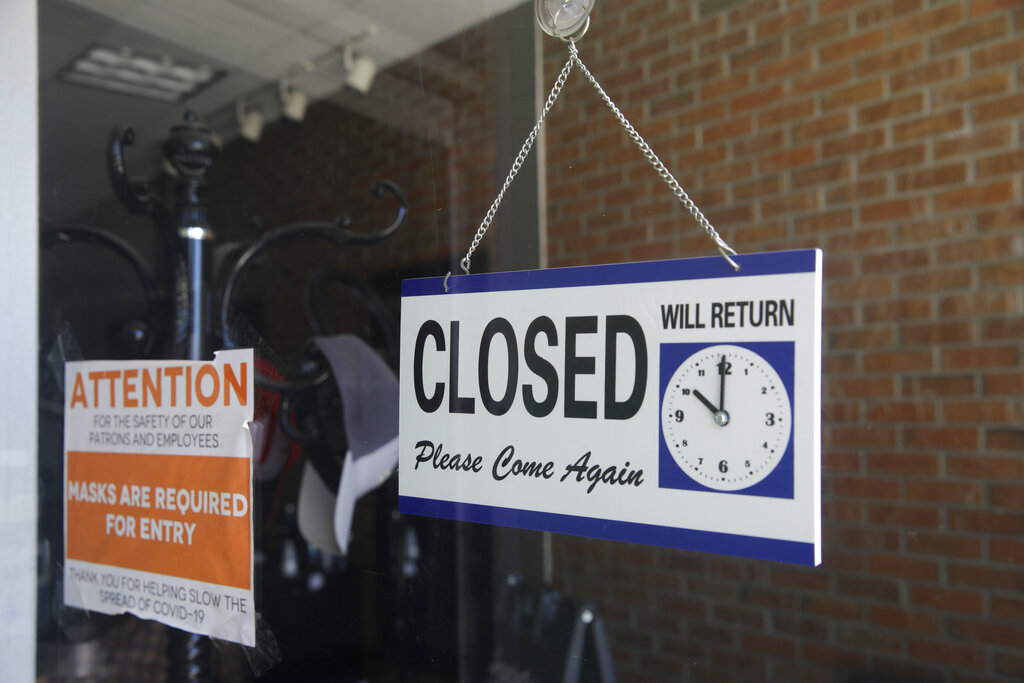 a closed sign hangs in the window of a barber shop in Burbank, California